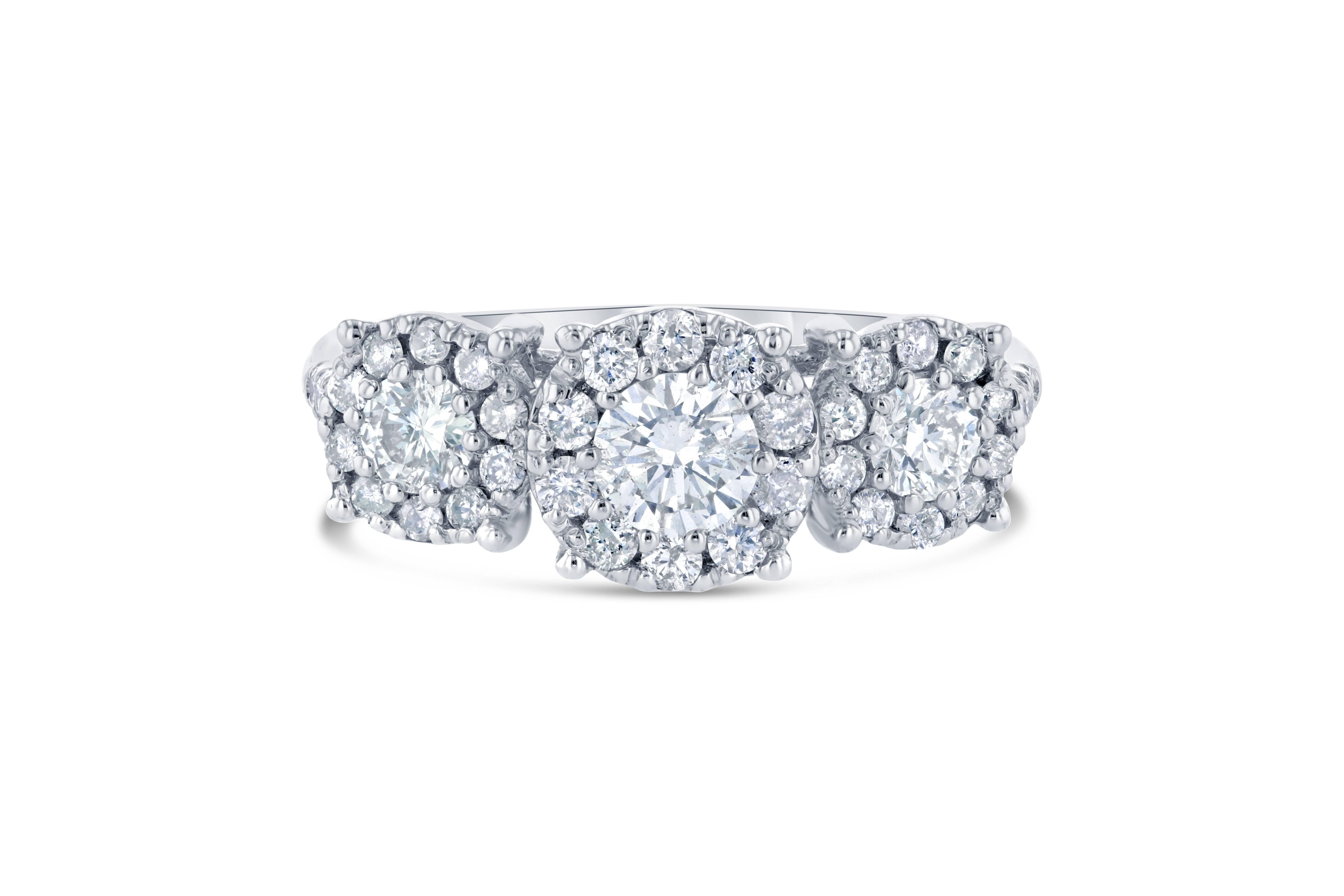 A beautiful round cut diamond three stone ring set in a round invisible setting creating a larger look for the entire ring!

There are 3 Round Cut Diamonds that weigh 0.73 Carats surrounded by 36 Round Cut Diamonds weighing 0.50 Carats. The total