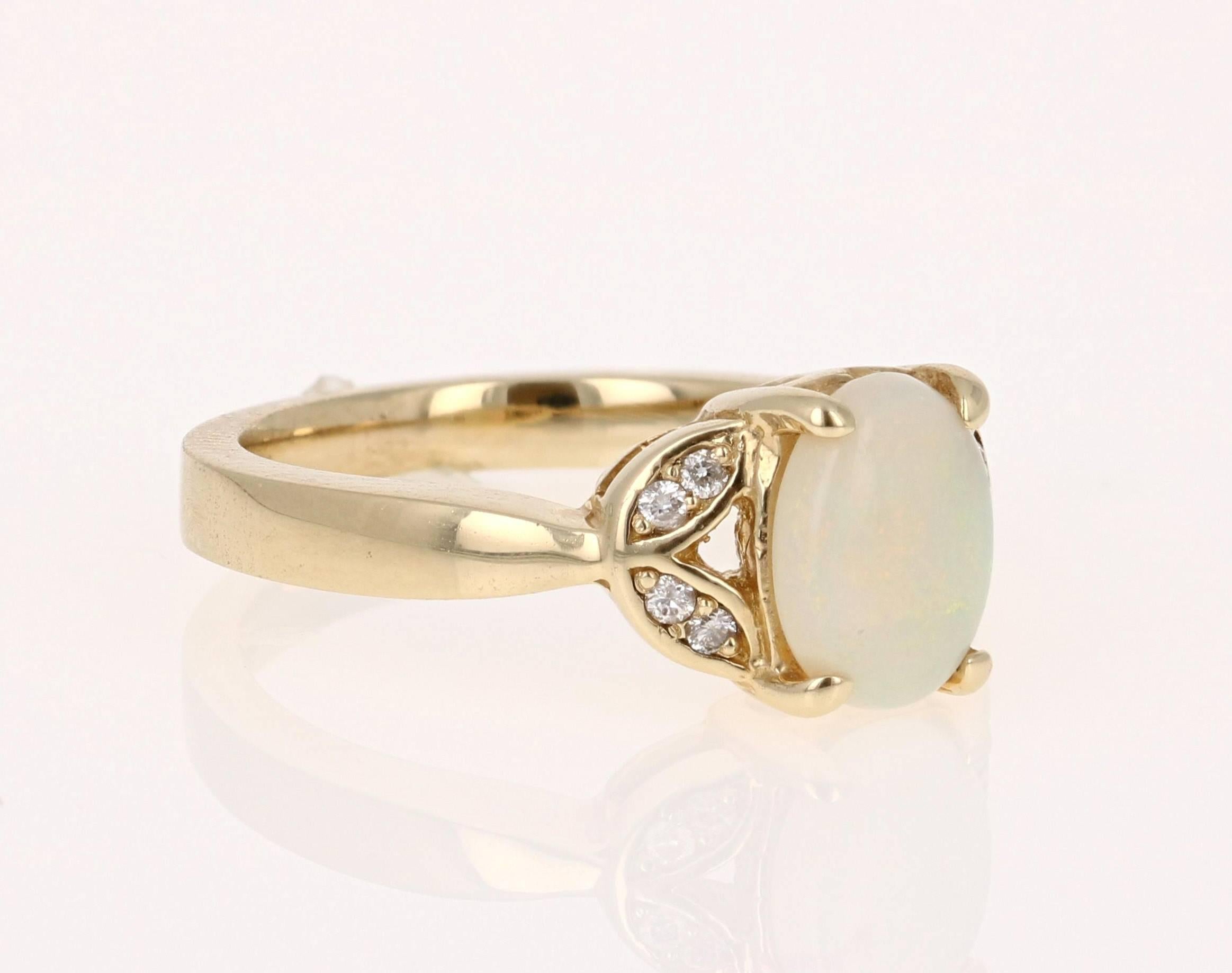 Delicate and dainty Opal and Diamond Ring in 14K Yellow Gold.  The Opal in this ring weighs 0.98 carats and is surrounded by 8 Round Cut Diamonds that weigh 0.08 carat.  The total carat weight of this ring is 1.06 carats.  The ring is a size 6.75