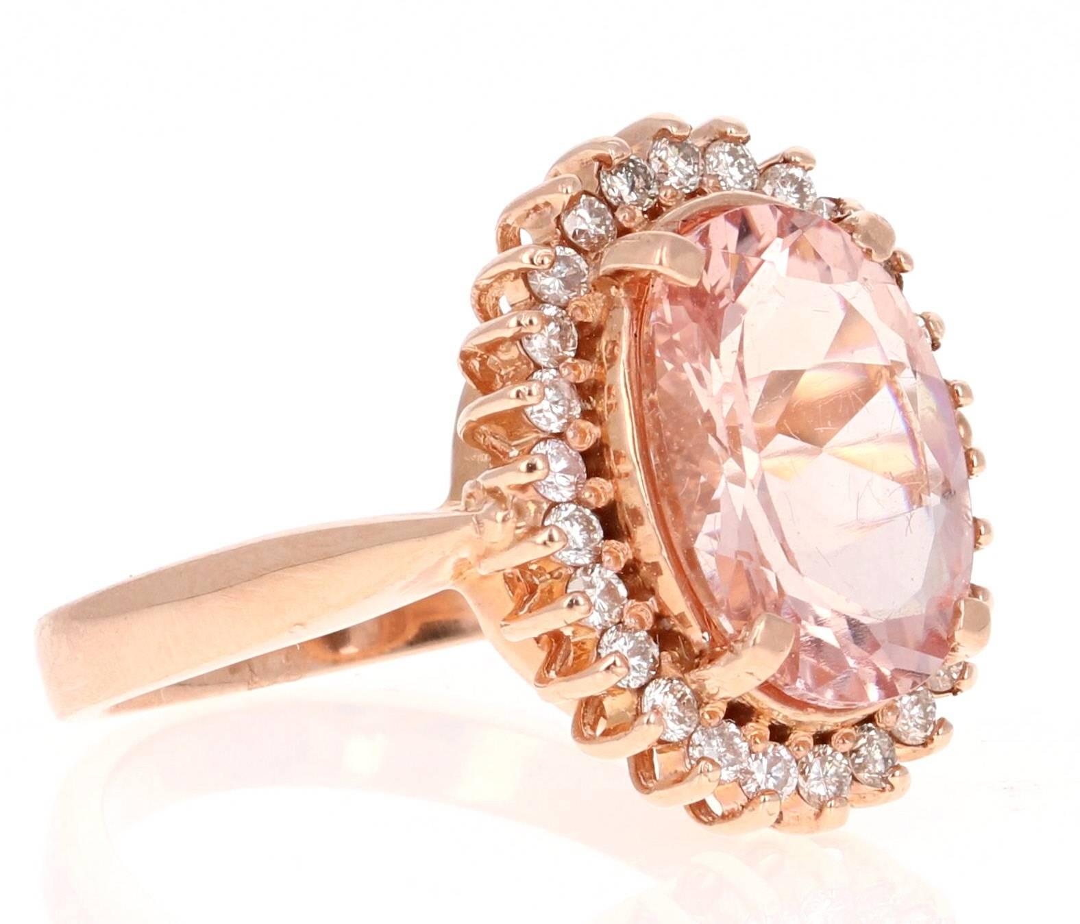 This classic Morganite Ring has an Oval Cut 3.93 Carat Morganite as its center and is surrounded by 26 Round Cut Diamonds that weigh 0.49 Carats.  The total carat weight of the ring is 4.41 Carats. The Clarity and Color of the Diamonds are VS-H.