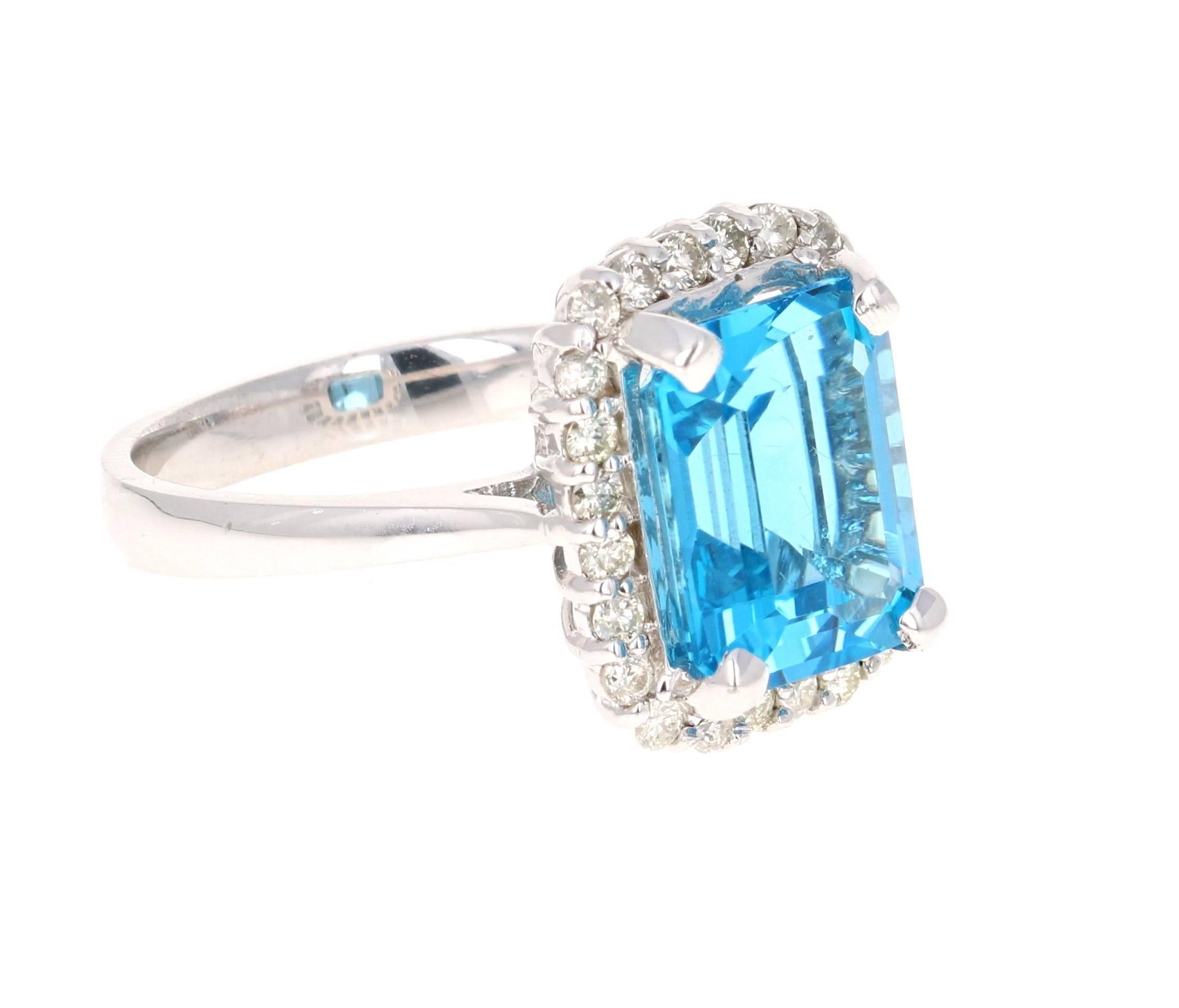 This beautiful Emerald Cut Blue Topaz and Diamond ring has a stunning 5.78 Carat Blue Topaz and its surrounded by 24 Round Cut Diamonds that weigh 0.44 Carats. The total carat weight of the ring is 6.22 Carats. The setting is crafted in 14K White