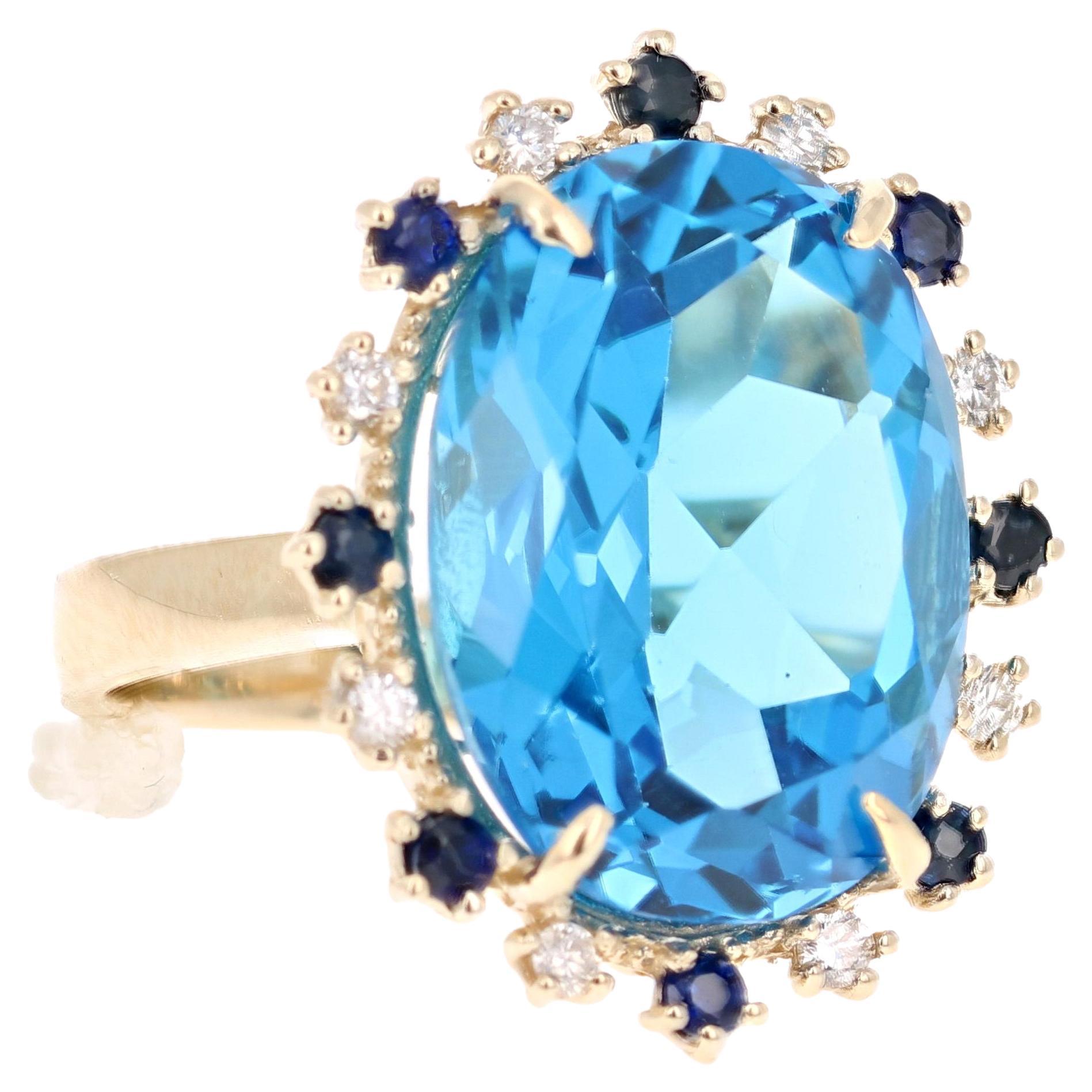 Beautiful to say the Least! This magnificent Oval cut 20.73 Carat Blue Topaz is surrounded by 8 Round Cut Diamonds that weigh 0.25 Carats (Clarity: SI, Color: F) and 8 Blue Sapphires that weigh 0.52 Carats. The total carat weight of the ring is