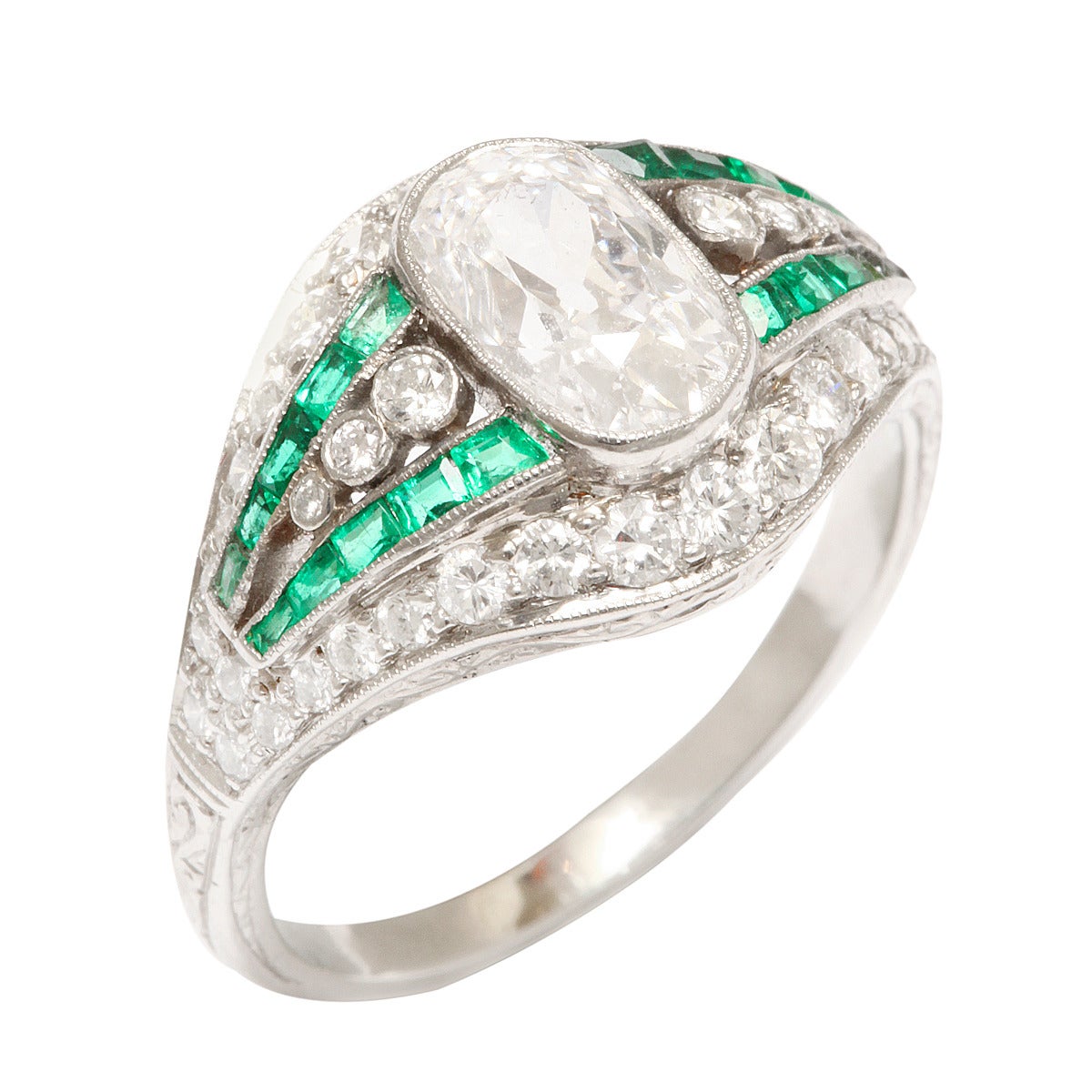 Edwardian-era diamond ring set in platinum, featuring an approximately 1.25 ct central diamond, and with emerald bands.

English, ca. 1915