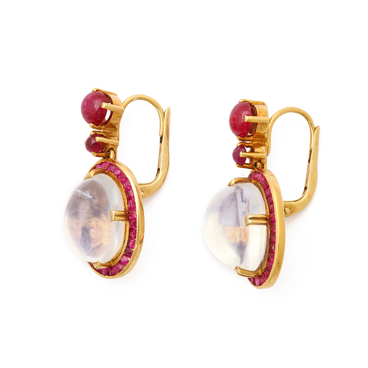 Victorian cabochon moonstone and cabochon ruby drop earrings, with calibre ruby border, set in gold.