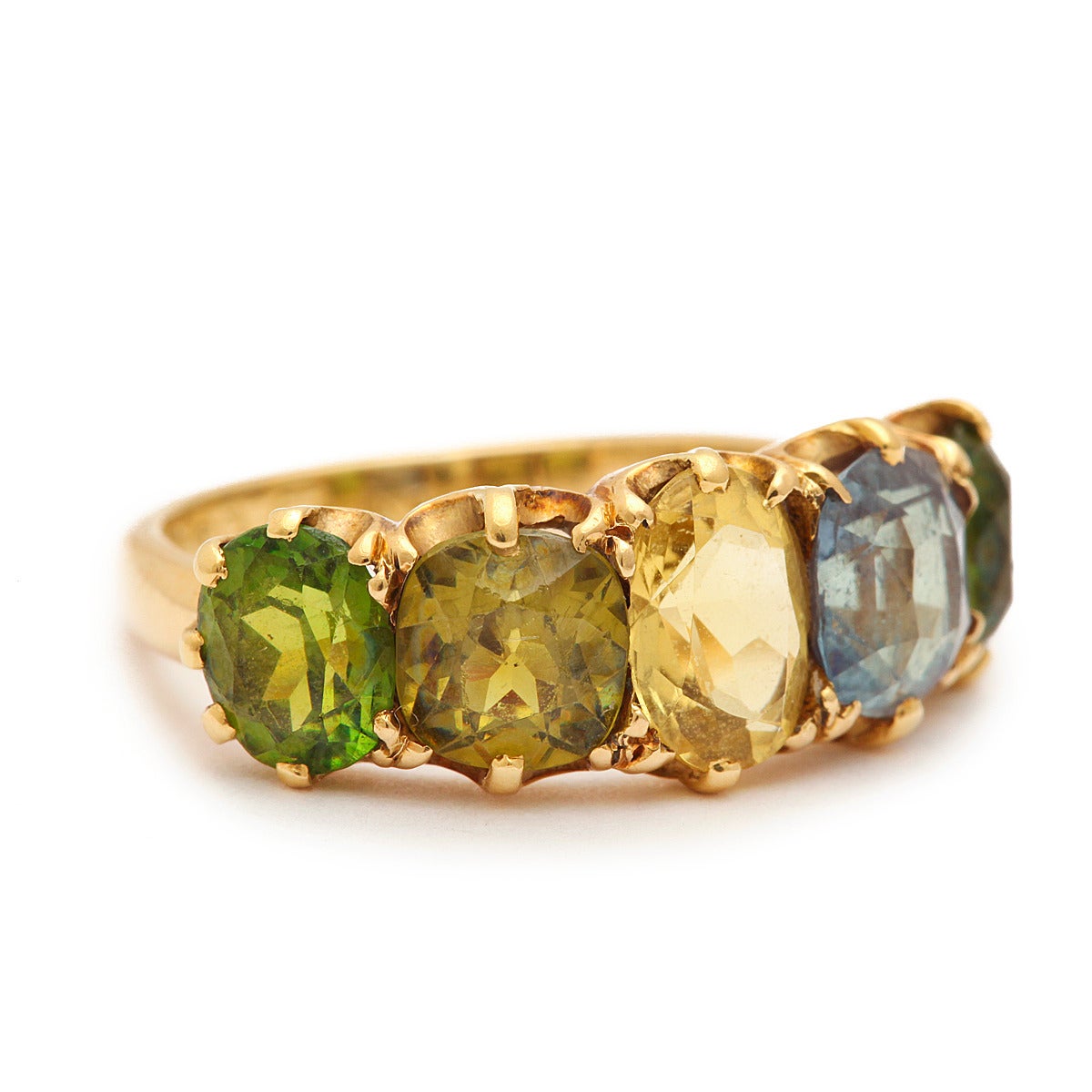 Victorian half-hoop five-stone ring set in a gradation of autumnal hues with two demantoid garnets, one green sapphire, one yellow sapphire, and one alexandrite, set in a 15k yellow gold mount.

By W.G., London, 1888