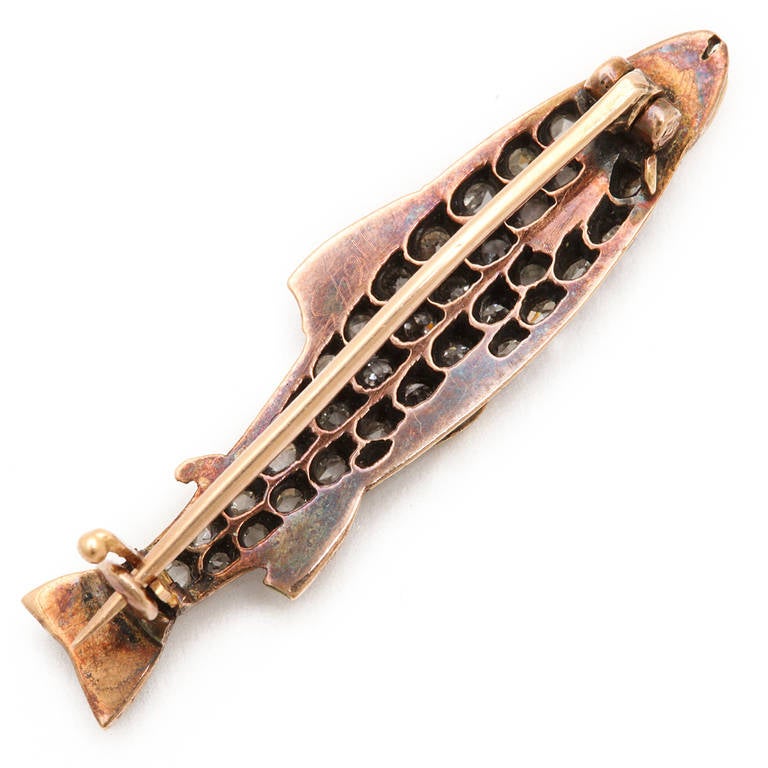 Old mine and crown rose diamond salmon brooch with enameled head and fins, set in silver and gold.