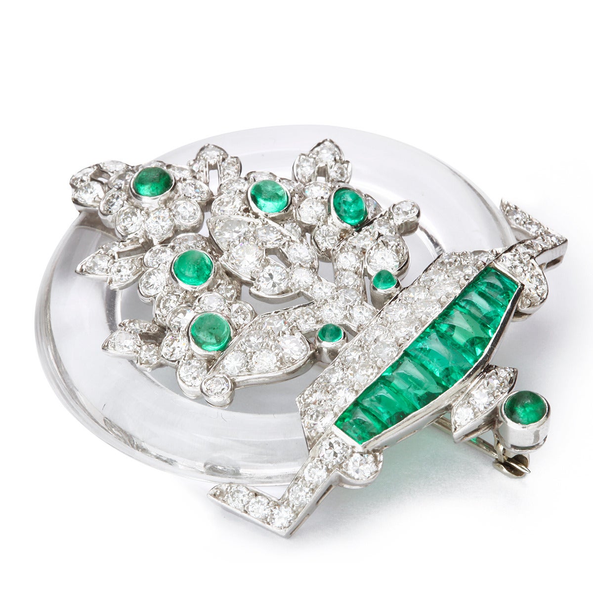 Art Deco rock crystal, emerald, and diamond circular brooch, set in platinum.

American, ca. 1935.
Length: 1 3/4 inches