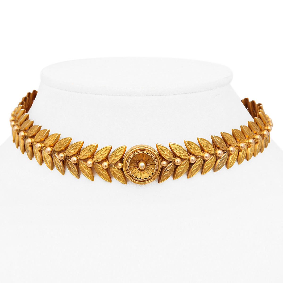 Roman Revival gold leaf-form choker ornamented with a central floral medallion.

English, ca. 1885.
Length: 13 1/2 inches