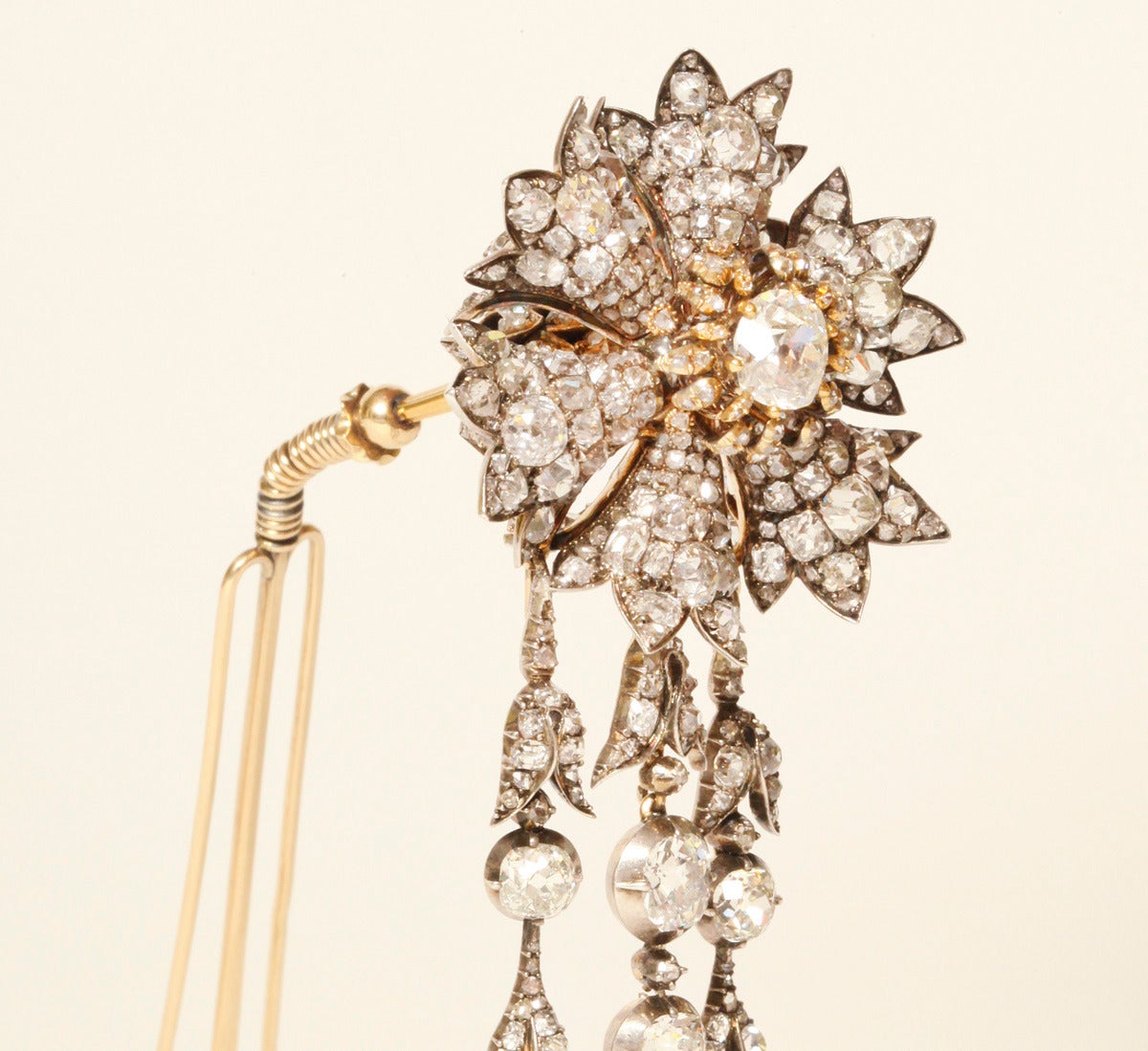 Diamond cornflower hair ornament, set en tremblant, with three detachable, articulated en pampille diamond strands, and mounted in gold and silver on a three-pronged comb. This jewel is similar in design to pieces in the French Crown Jewels, sold in