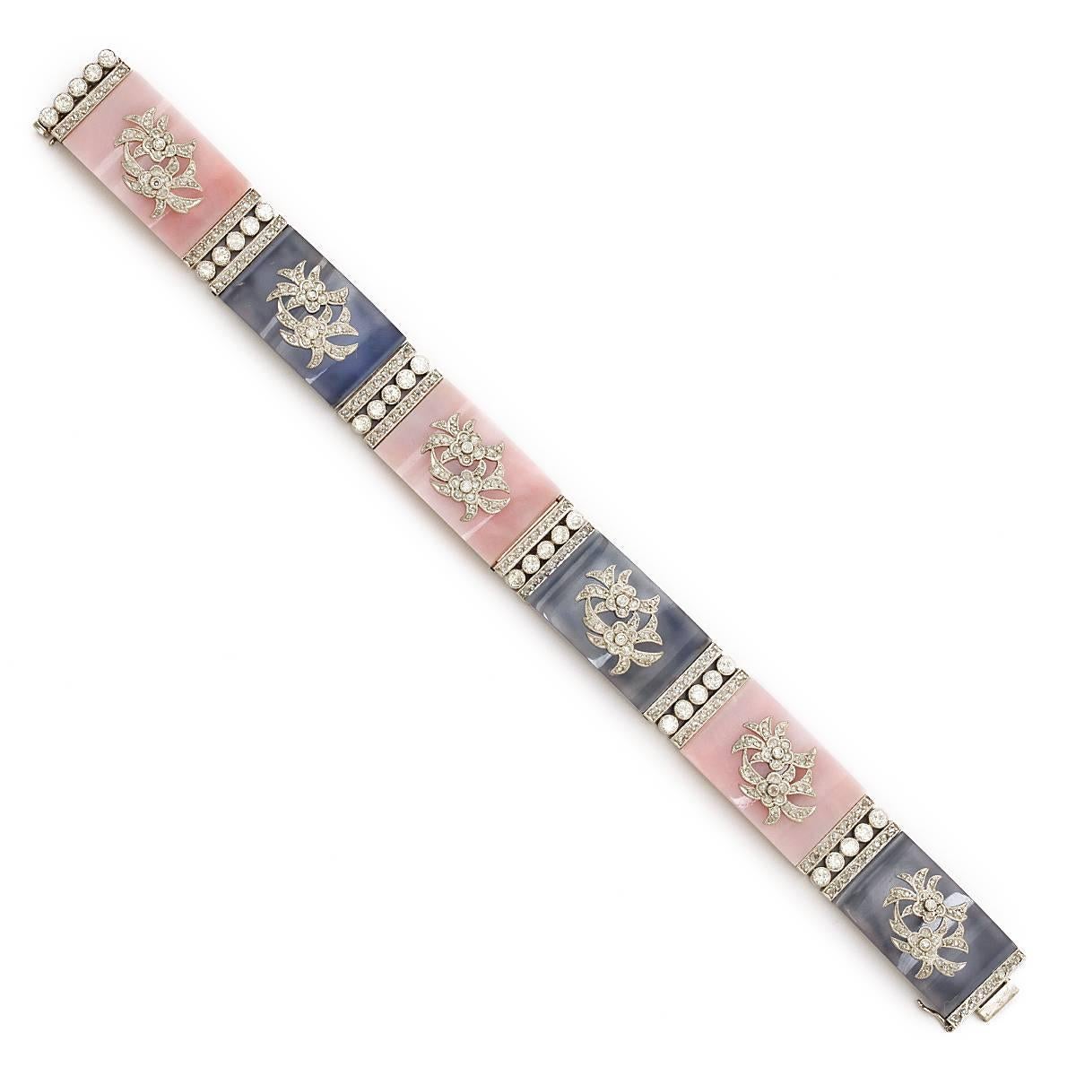 Edwardian period platinum bracelet composed of alternating pink agate and blue chalcedony panels with centering diamond floral motifs.

American, ca. 1915
Length: 7 inches