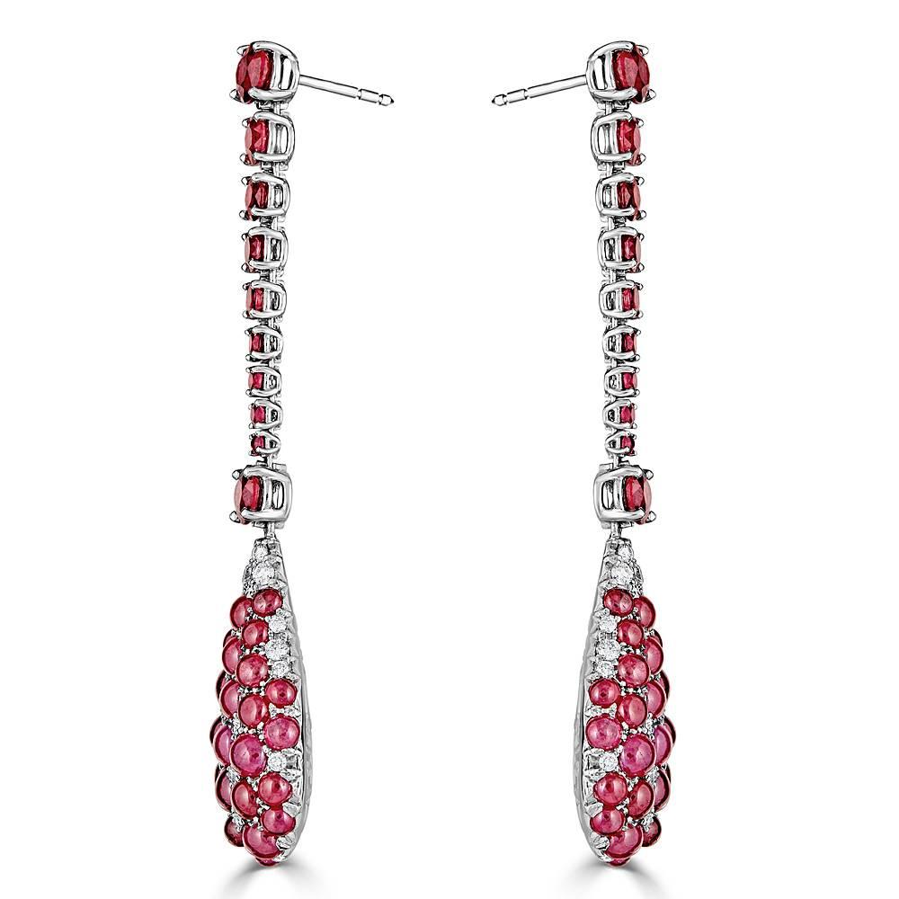 A pair of impressive drop earrings featuring 6.32 carat Natural Faceted Round Rubies and 15.80 carats Total of pave set Natural Cabochon Shaped Rubies. These handcrafted earrings are accented with 1.01 carats Total of pave set White Diamonds, all