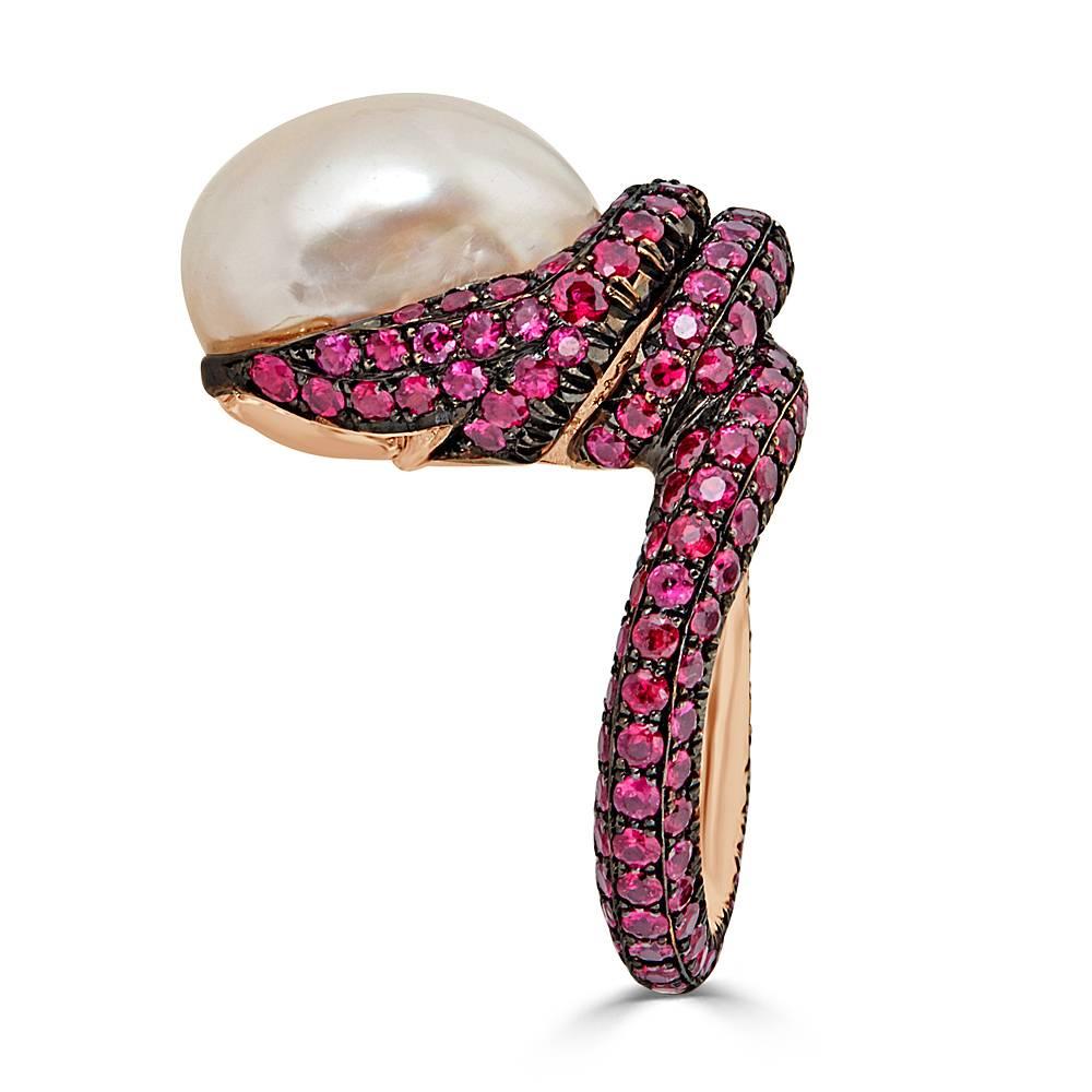 A Baroque Pearl ring, handcrafted in 18k Rose Gold and pave set with Round cut Natural Rubies. This ring features 170 pave set round cut Rubies for a total of 6.40 carats and a 16mm Natural Baroque Pearl with beautiful Pinkish White luster. The ring
