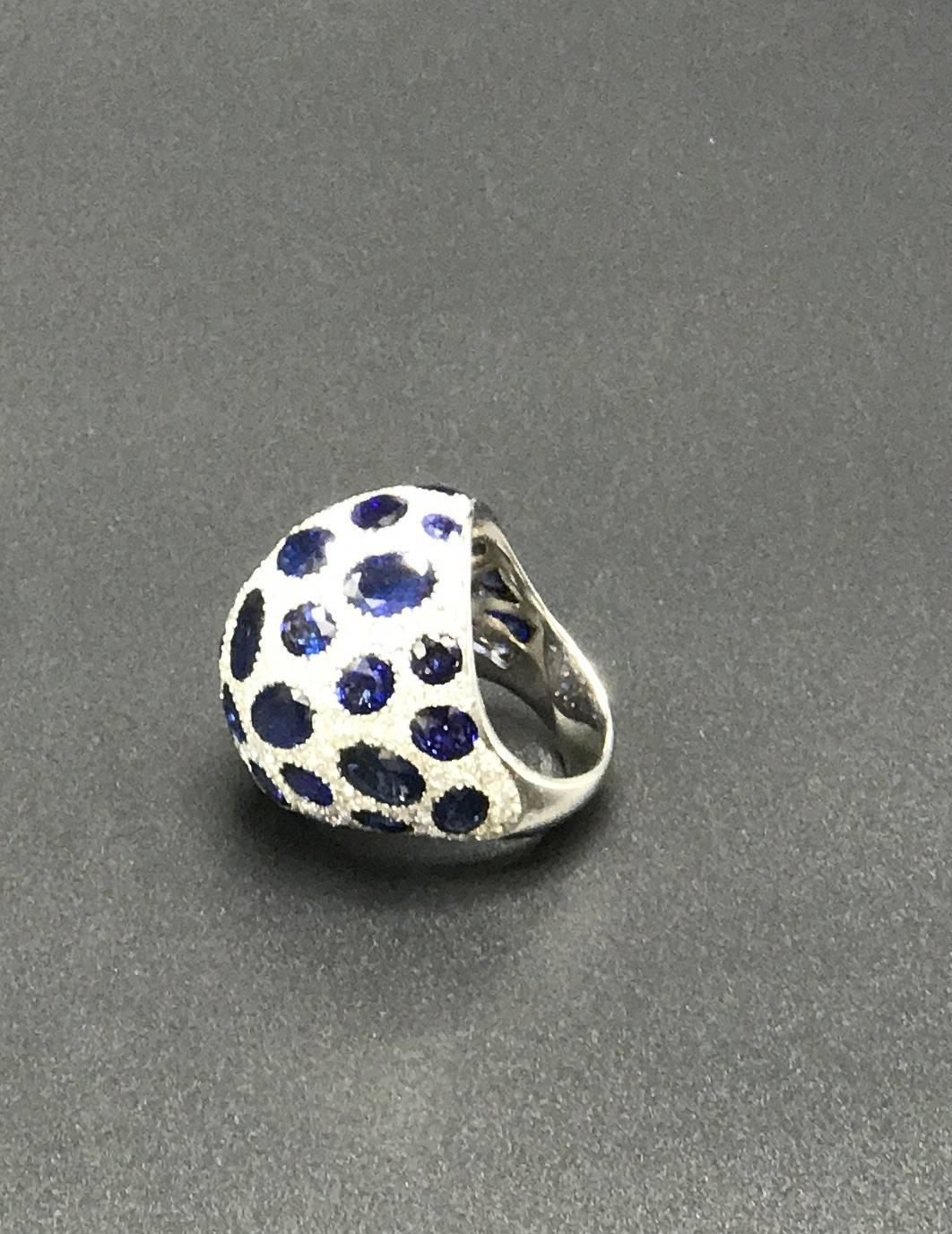 A handcrafted leopard motif Blue Sapphire and White Diamond Domed Ring in 18k White gold. This large domed ring features 10.50 carats of natural Blue Sapphires set with 5.85 carats of F/G Color VS Quality Diamonds in a leopard motif pattern. The