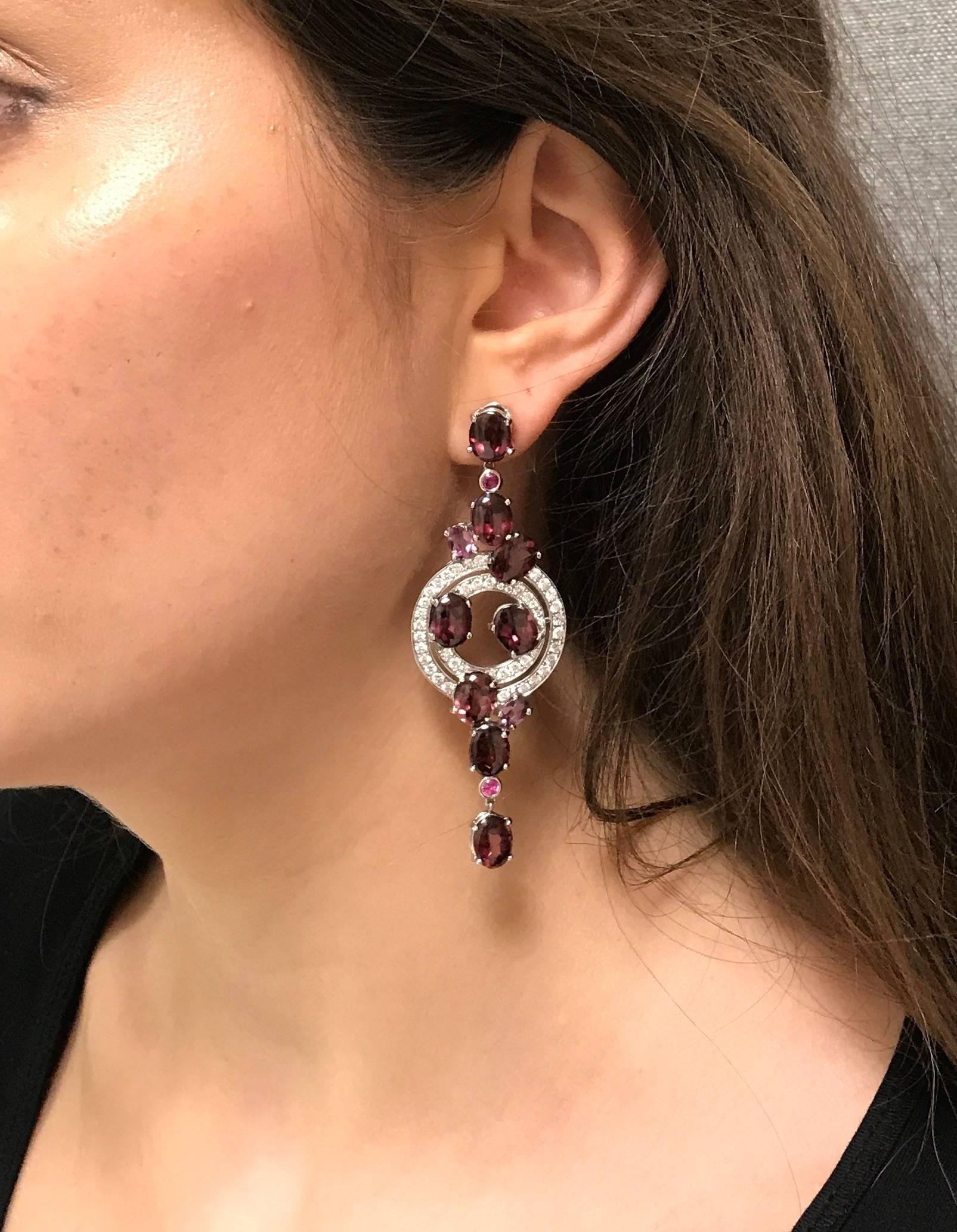 Presented here is a pair of beautiful Rhodolite Garnet, Pink Sapphire and Diamond earrings handcrafted in 18k white gold. These earrings feature 2.44 carats of F/G Color VS Clarity Diamonds pave set in a circular motif and accented with prong set