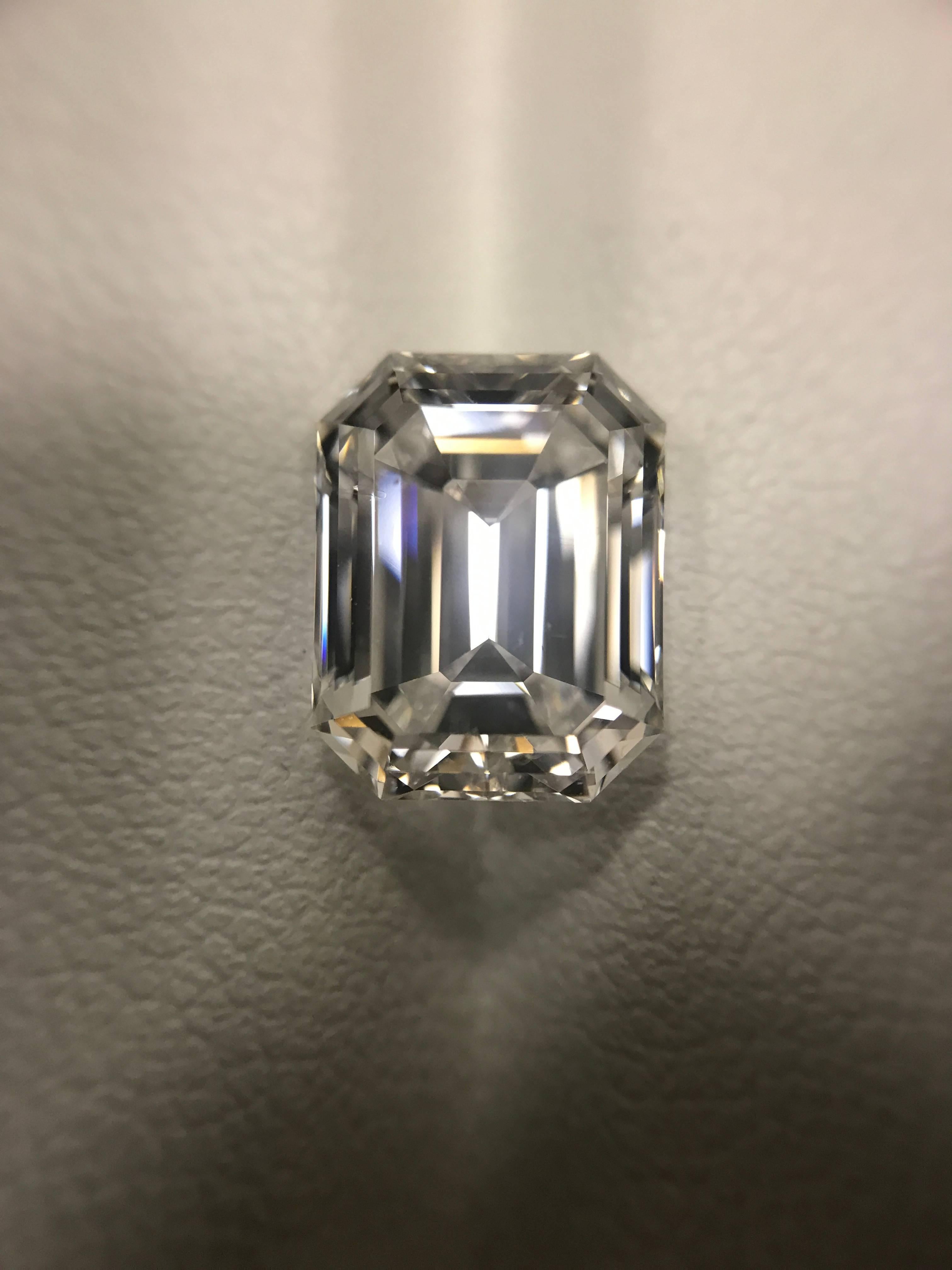 A classic 5.10 carat Emerald Cut diamond with E Color and VS2 Clarity and Excellent Polish and Excellent Symmetry set with two tapered baguette-cut diamonds totaling approx. 0.50 carat. Mounted in a hand made platinum three-stone ring with double