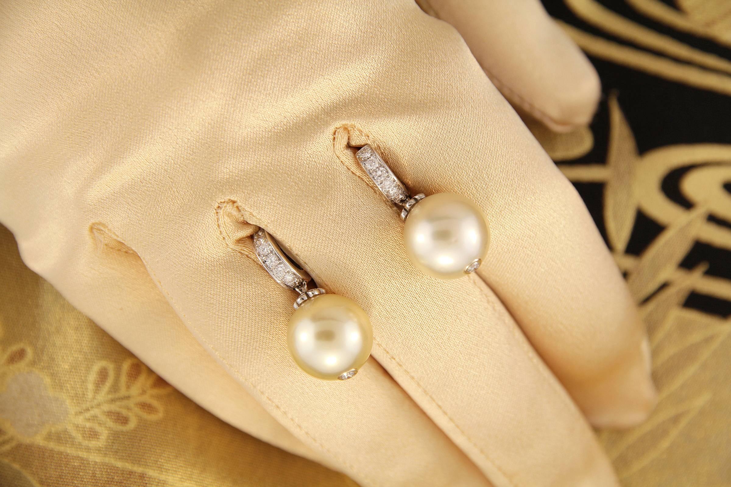 The two 12mm diameter golden South Sea pearls originate from the waters of Northwestern Australia. They display fine quality nacre and their natural color and luster have not been enhanced in any way.
The pearls are suspended from 2 hoops set with