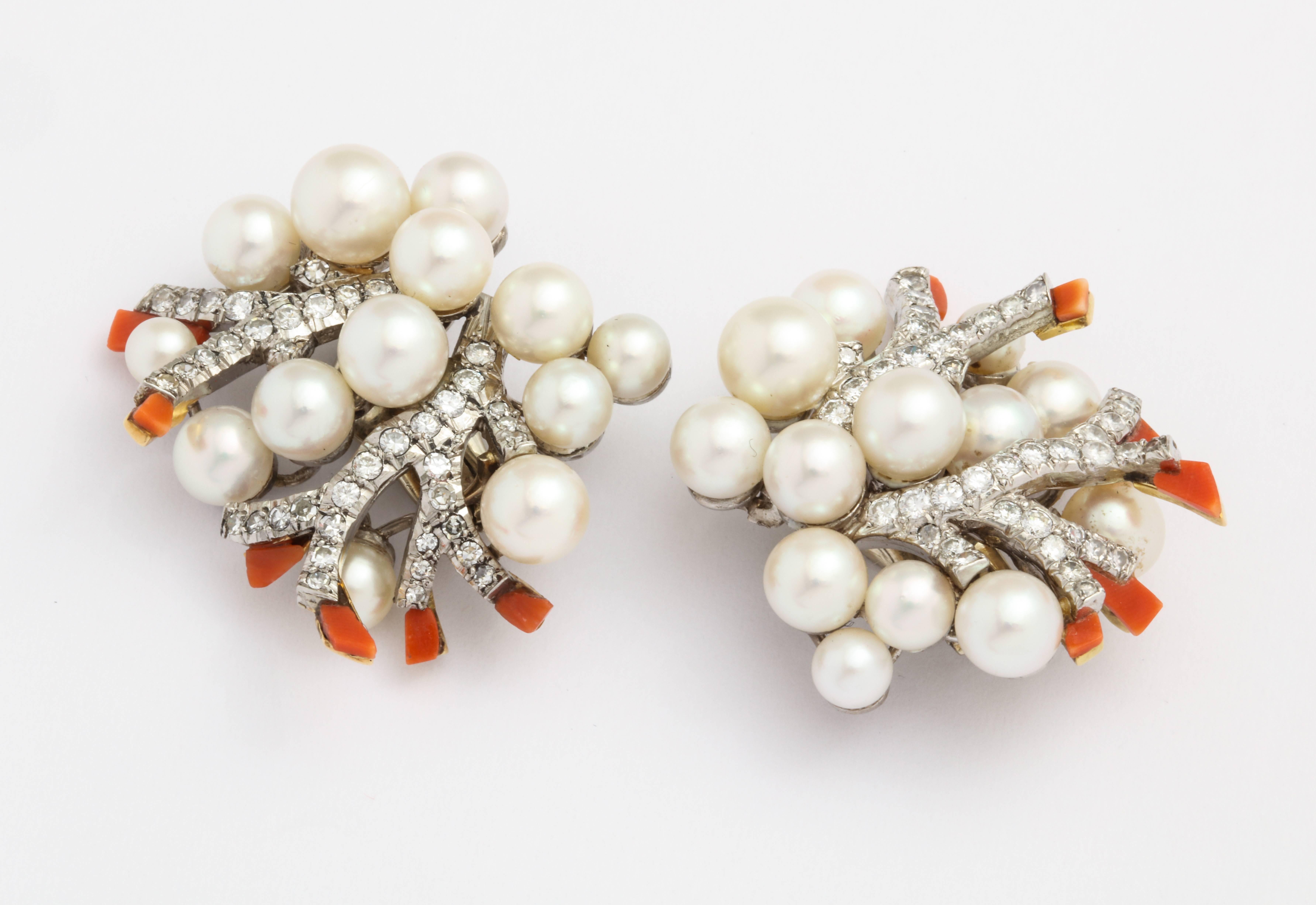A pair of platinum ear clips made by Verdura. On each earring there are 13 round cultured pearls and 6 pieces of coral. The total estimated diamond weight for both earrings is 2.34 carats. Made in 1960. 

Provenance: belonged to Baron Alain de