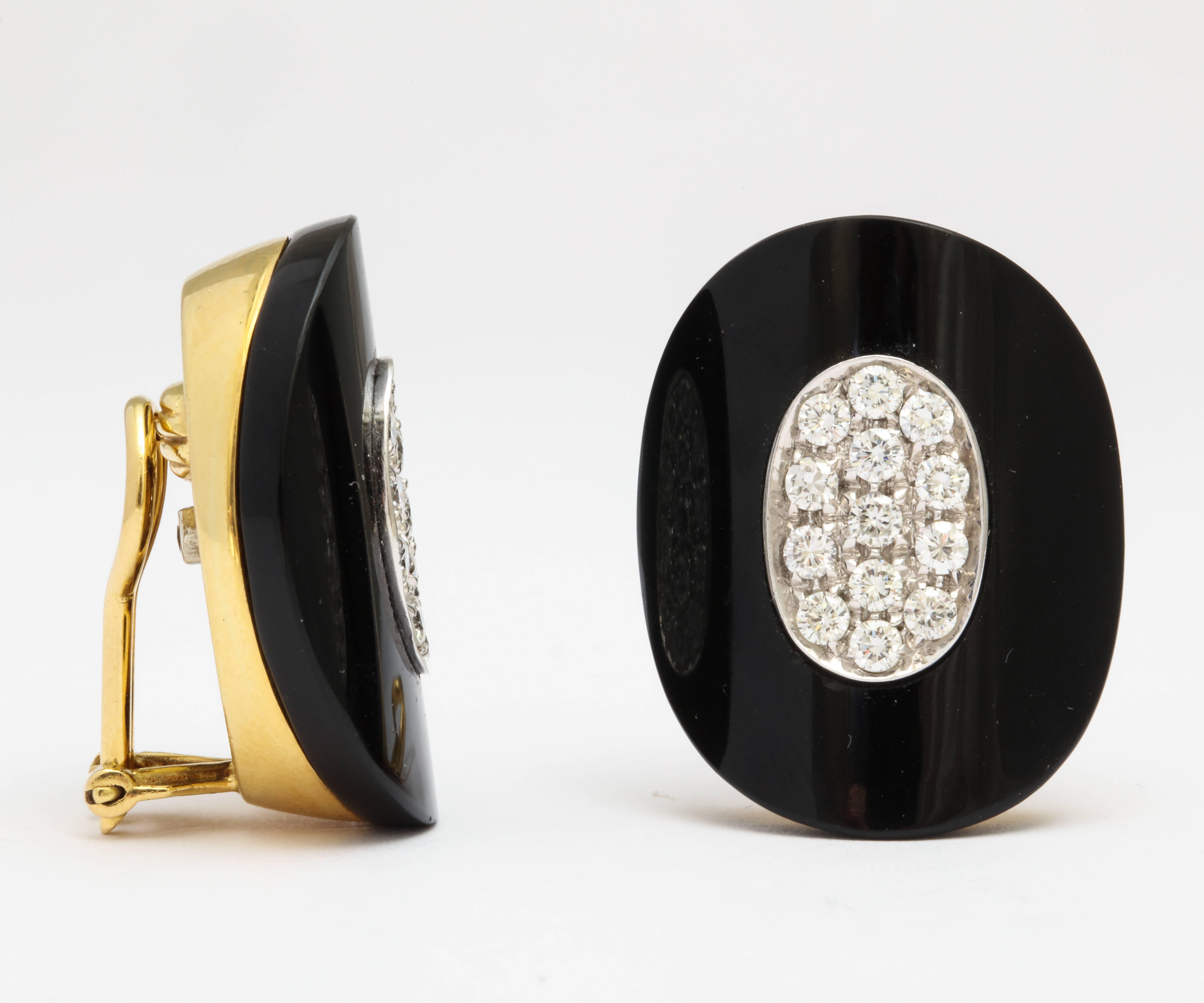 A pair of 18 karat yellow gold, diamond and onyx earclips. The total diamond weight is approximately 2 carats. Stamped 750 for 18 karat and an undistinguishable signature.  Posts can be added at no additional cost.