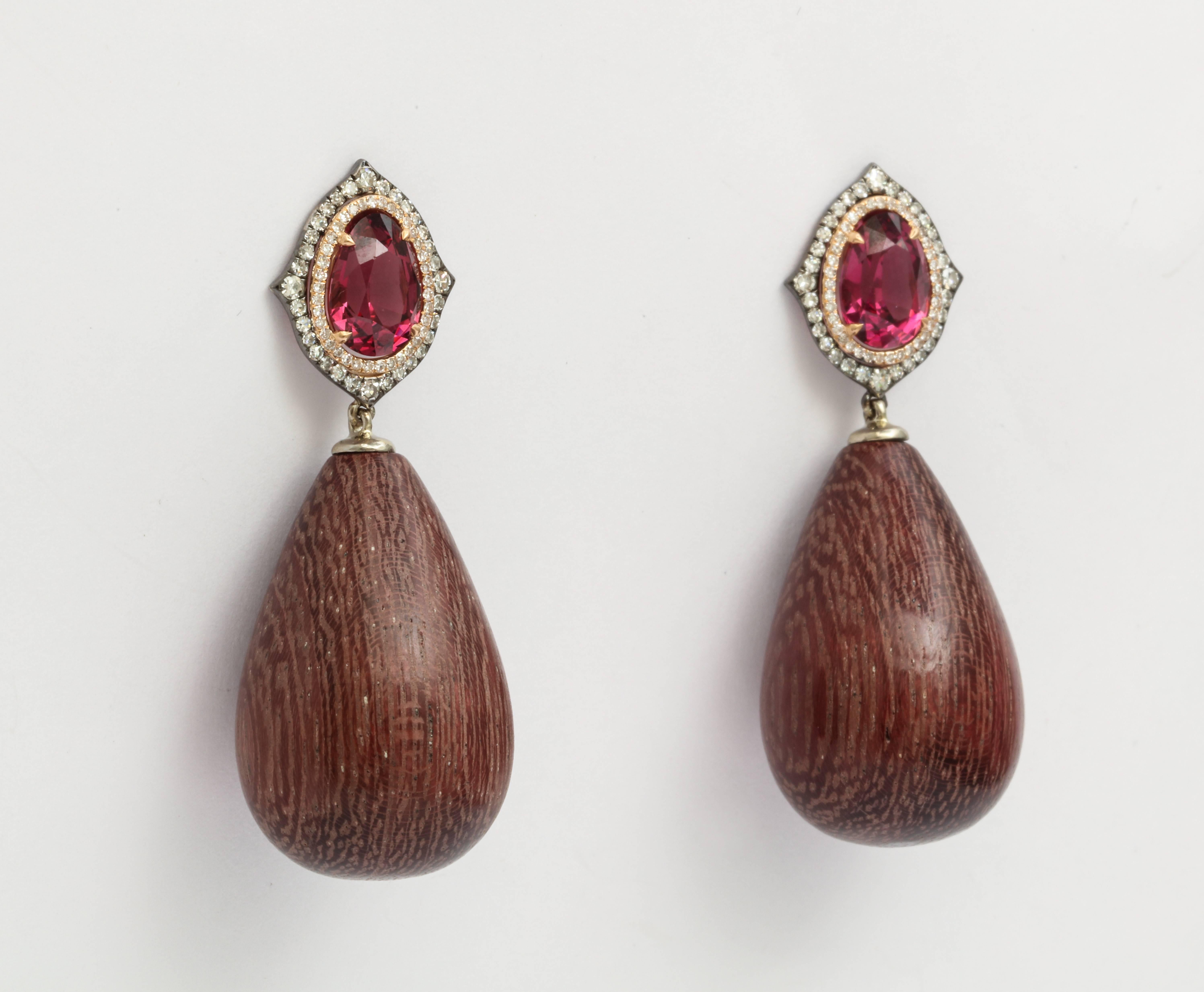 A pair of earrings featuring polished amaranth wood drops measuring 27 x 18mm. Set with 4.04 carats of rhodolite and 0.51 carats of diamonds in 18 karat gold. Friction backs.
