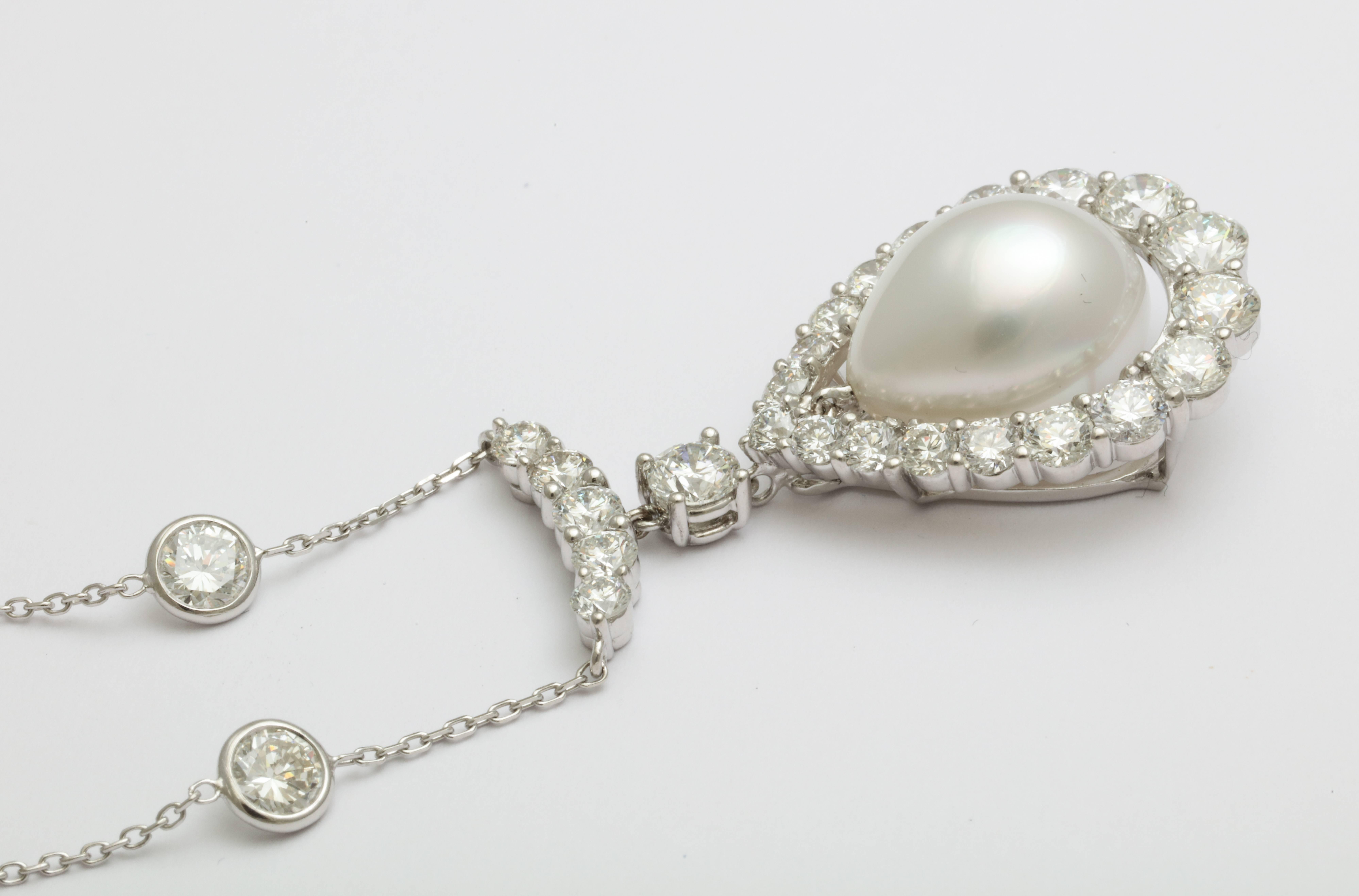 Superb modern twist on a classic.  A platinum necklace featuring a large, beautifully tapered shape South Sea pearl drop (16 x 12.8 mm) surrounded by top quality diamonds with a total weight of 4.24 carats. The chain features diamonds with a total