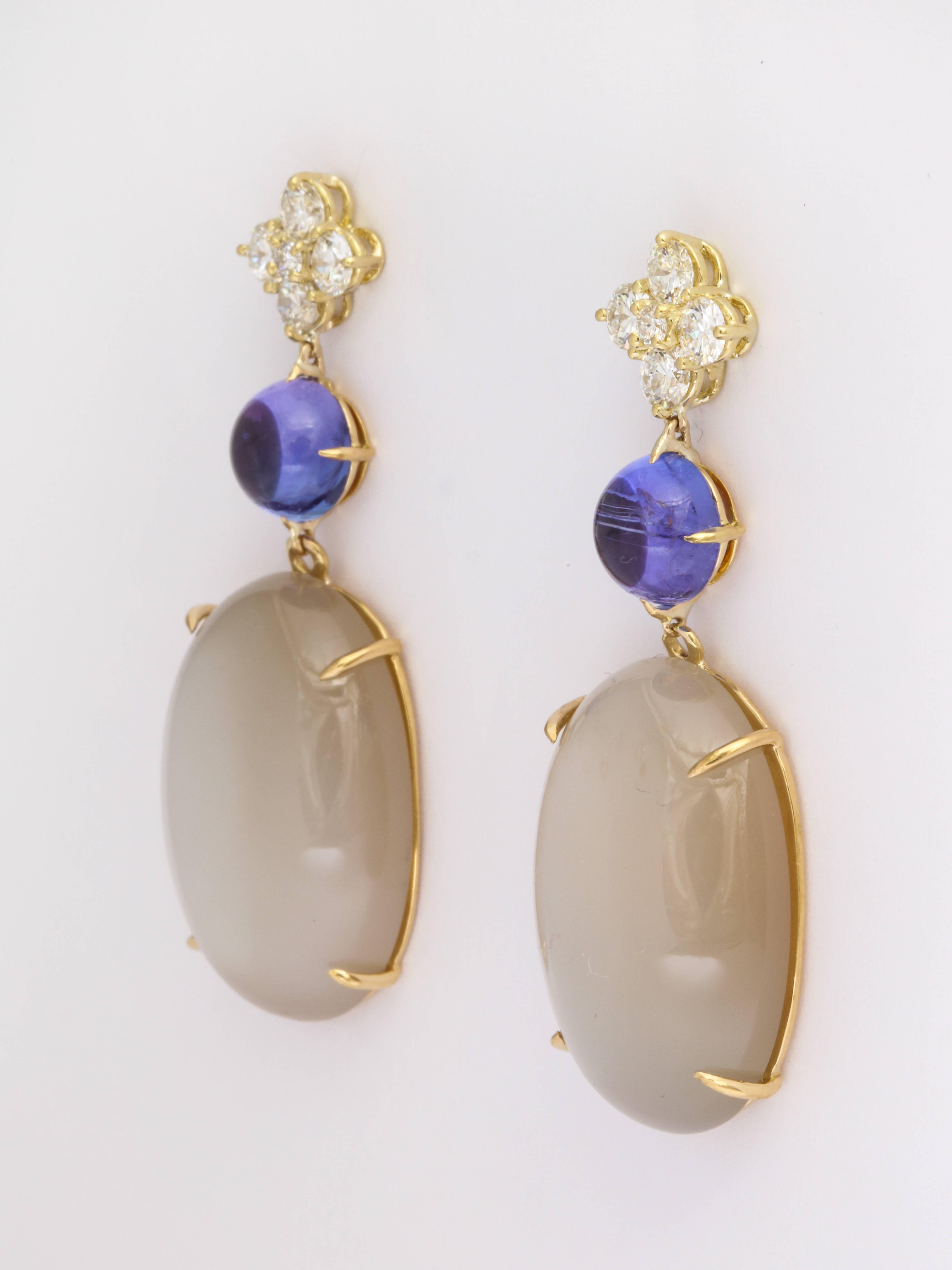 A day into night earring composed of round brilliant diamonds, bright blue tanzanite and large, grey moonstone set in handmade 18KYG. 8 Diamonds = 1.30 cts TW  Sold with our specially designed friction backs that help balance large earrings,