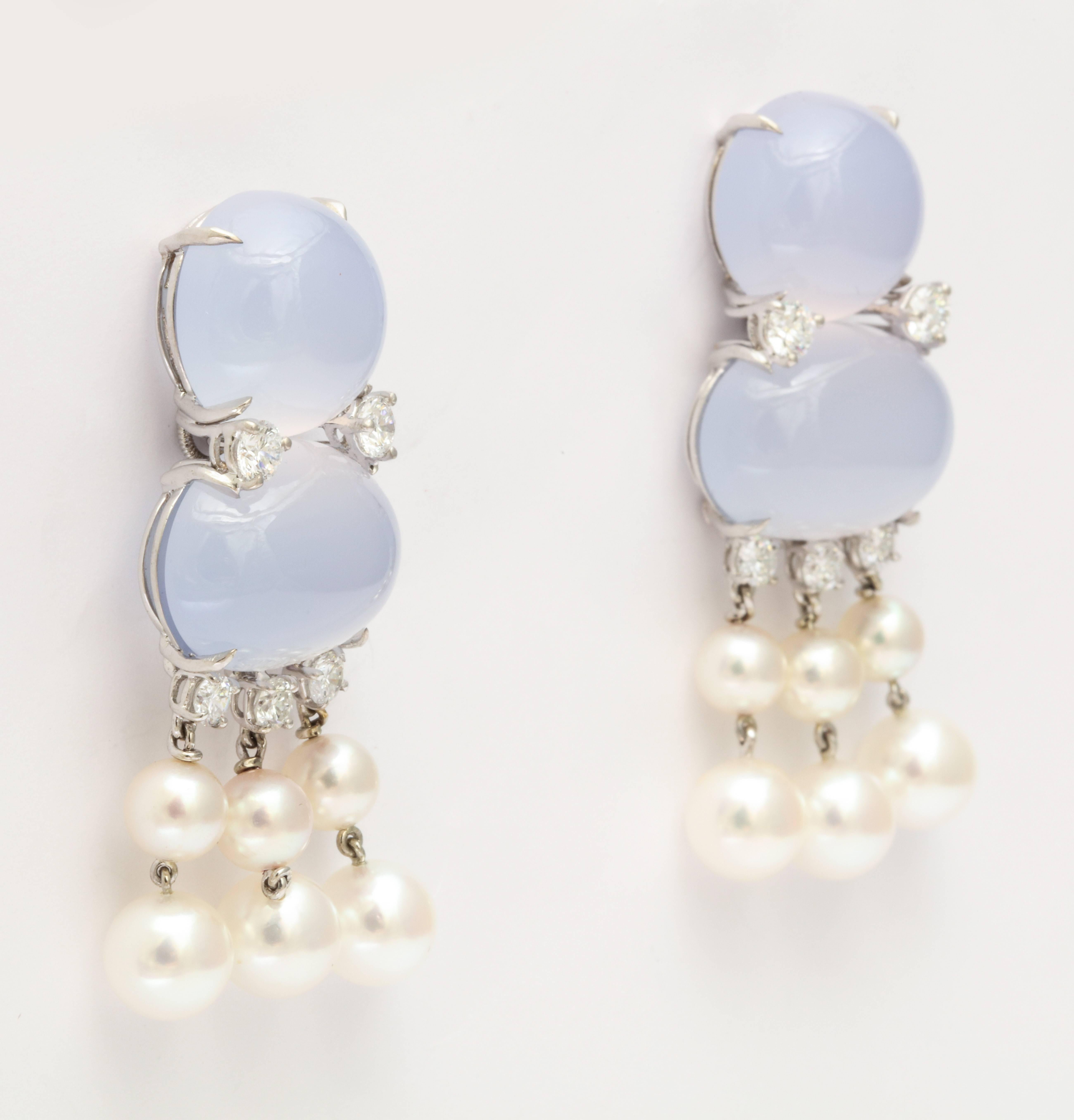 A pair of festive yet elegant dangle earrings made in 18 karat white gold featuring chalcedony, cultured pearl and white round brilliant diamonds.  Each earring has 6 cultured pearls designed as a graduated fringe. There is a total diamond weight of