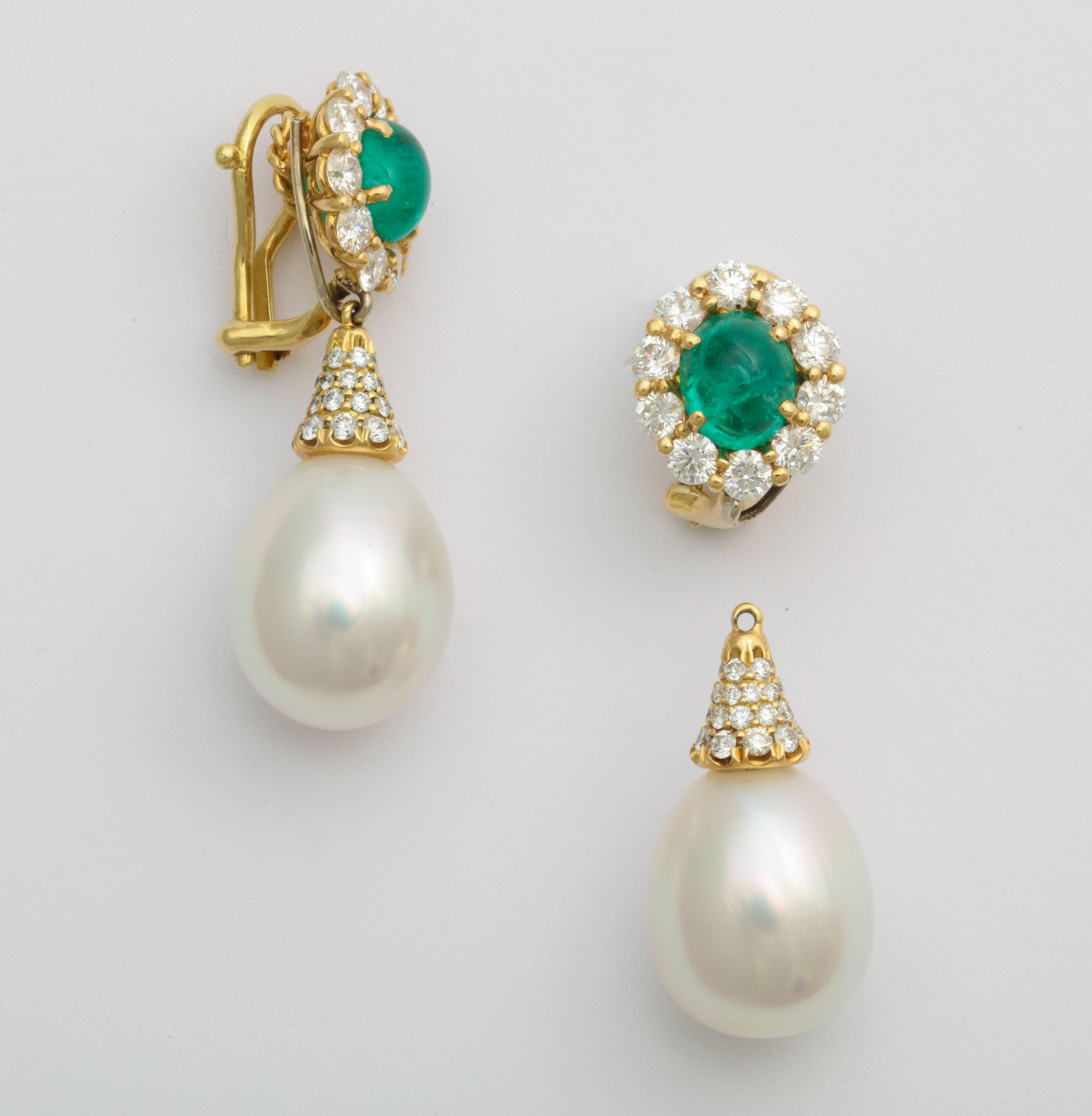 Emerald cabochon cut center stones are surrounded by a row of round brilliant diamonds in a shared-prong setting, with removable pave diamond and South Sea pearl drop pendants. Timeless design in a perfect day/night earring for emerald and pearl