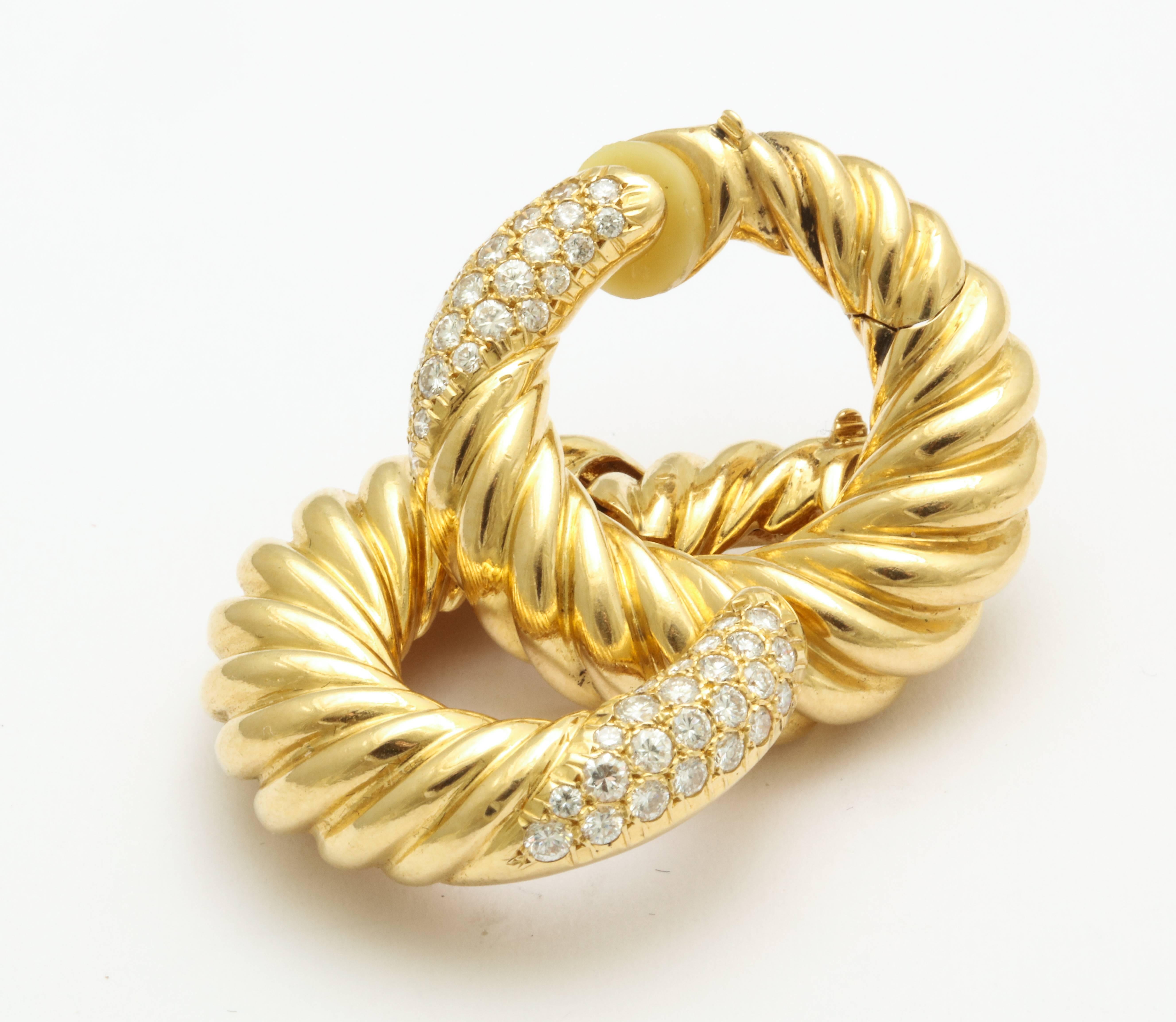 A pair of hoop clip on earrings by Van Cleef and Arpels accented with approximately 1.32 carats of diamonds. Set in 18 karat yellow gold. French marks. Circa 1990s. Clip hinges for easy on and off with great balance.