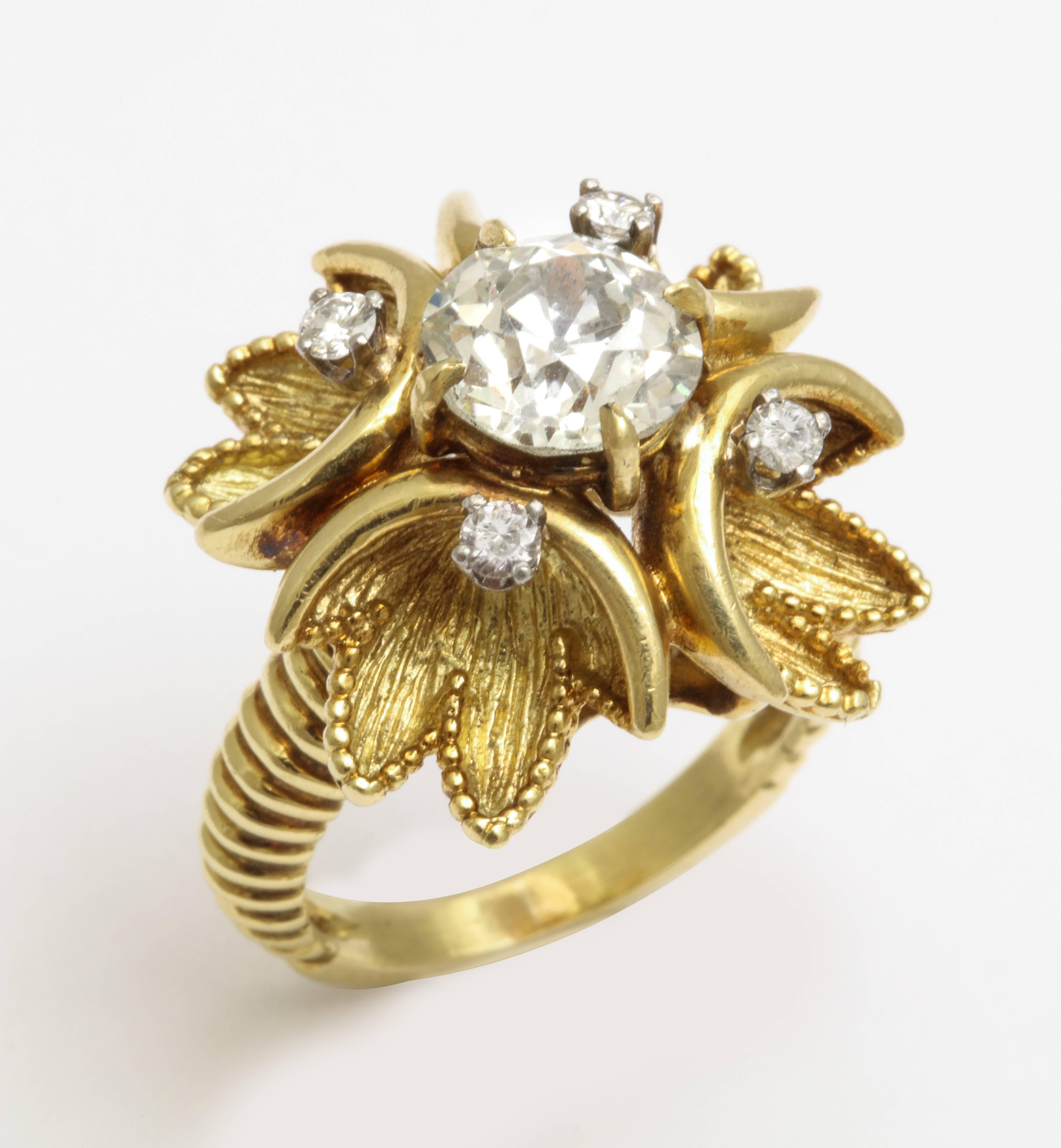 A cocktail ring by Cartier featuring a 2.25 carat old european cut diamond center. Flanked by four round brilliant cut diamonds with a total estimated weight of 0.12 carats. Set in 18 karat yellow gold and signed Cartier. Circa 1950s. Ring size 7.
