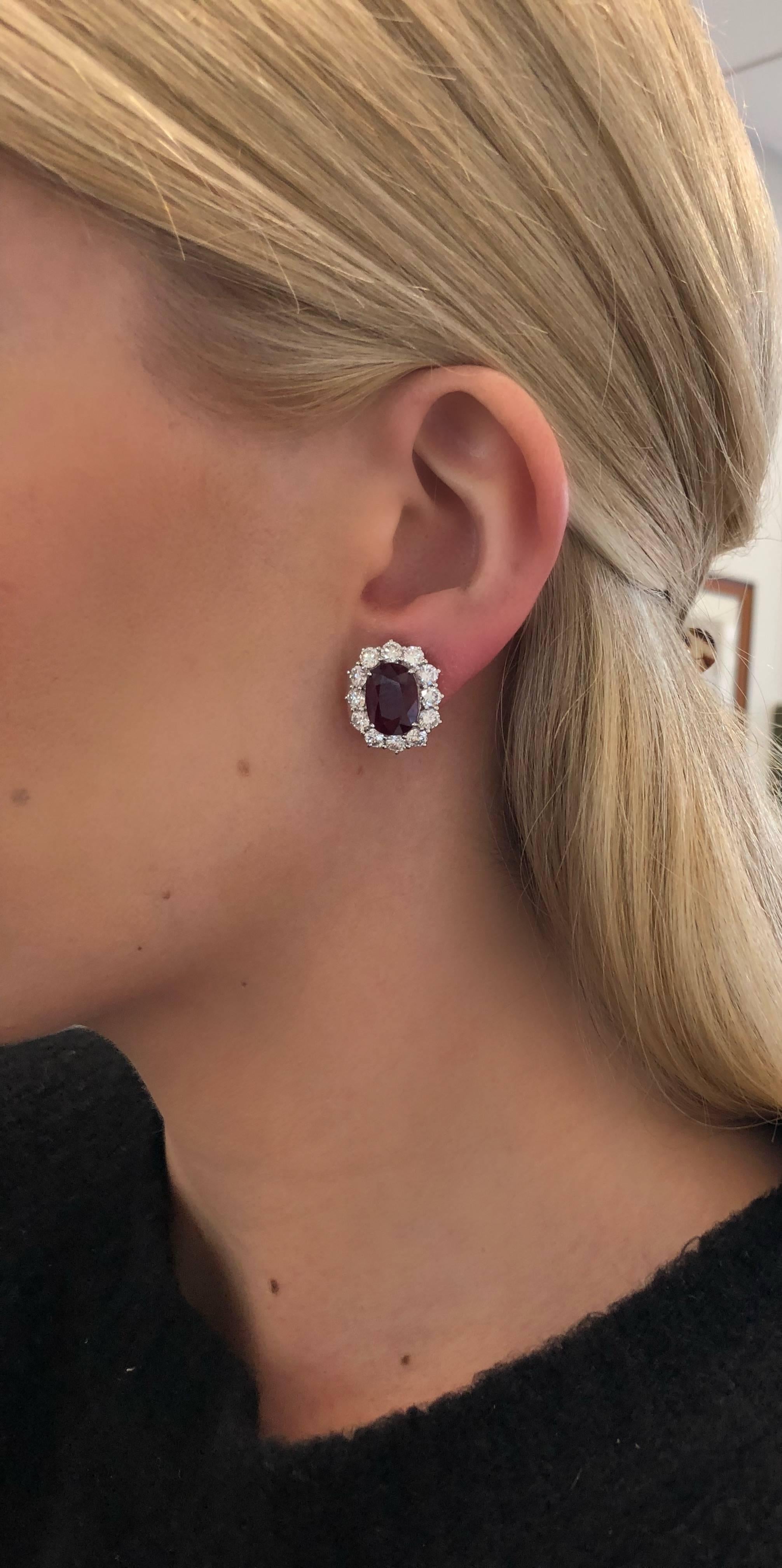Classic yet wearable. A fine pair of ruby earrings, featuring a well-cut and attractive matched pair of impressive size oval rubies, each with a rich, red color weighing 3.95 and 4.00 carats. Set in 18 karat white gold with a surround of brilliant
