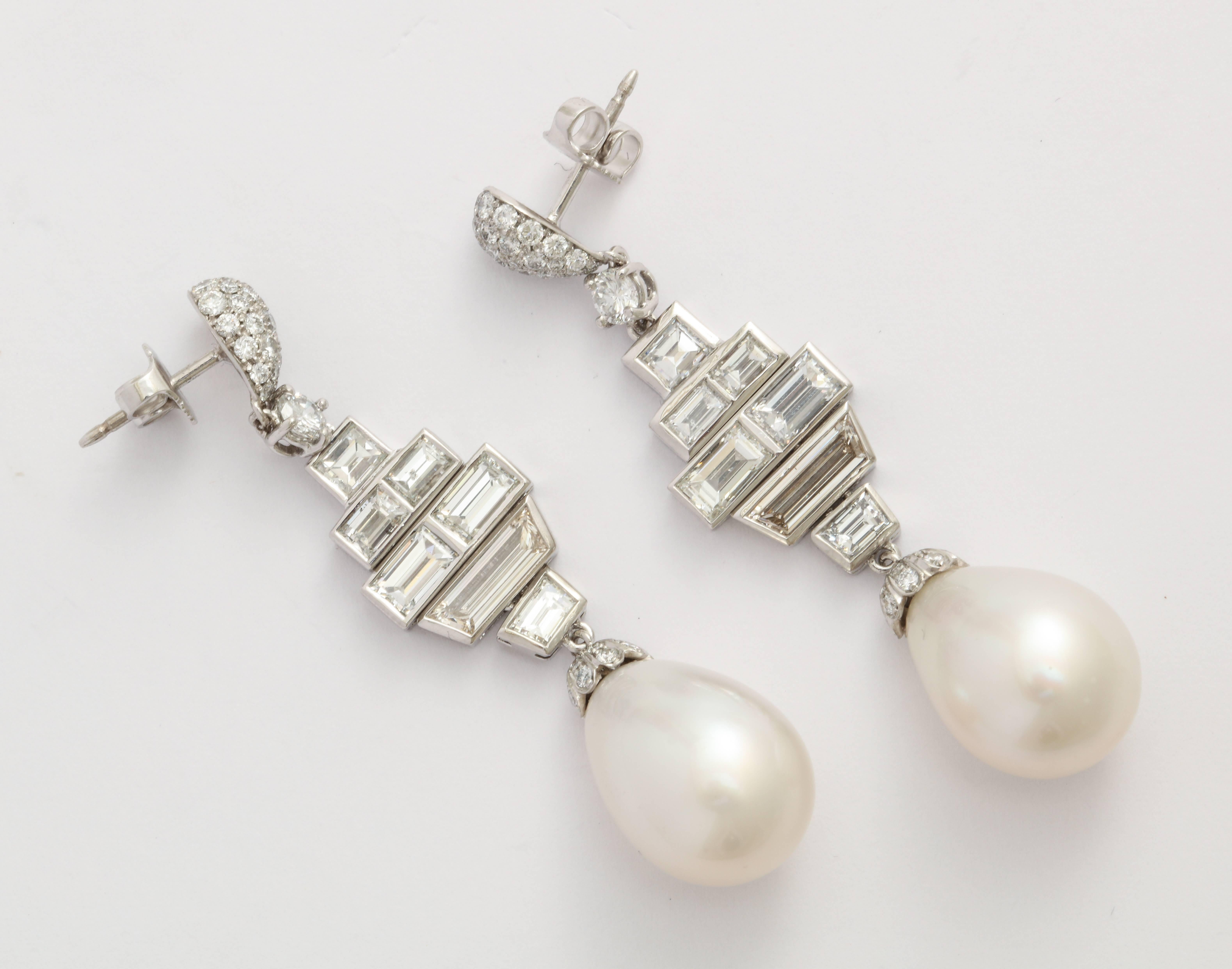 Sensuous silhouette of diamond baguettes and round diamond pave detail helps show off this beautifully shaped, high-luster pair of south sea cultured pearl drops. The total diamond weight is estimated to approximately 4.03 carats.  A fabulous