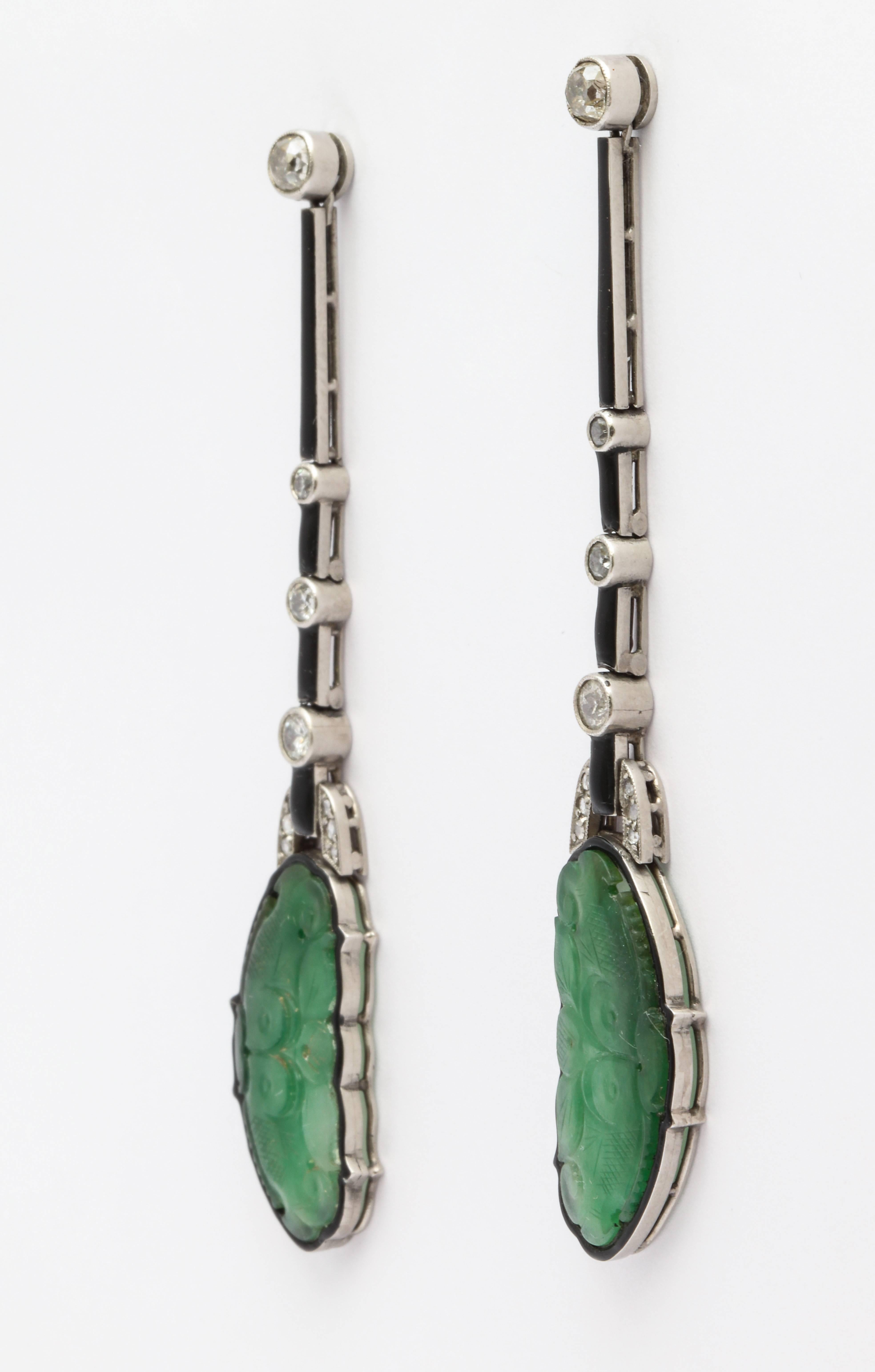 Art Deco earring with carved Jade depicting two fish kissing. Diamond accents weigh approximately 0.75carats total and fine black enamel detail give this antique earrings a special charm.