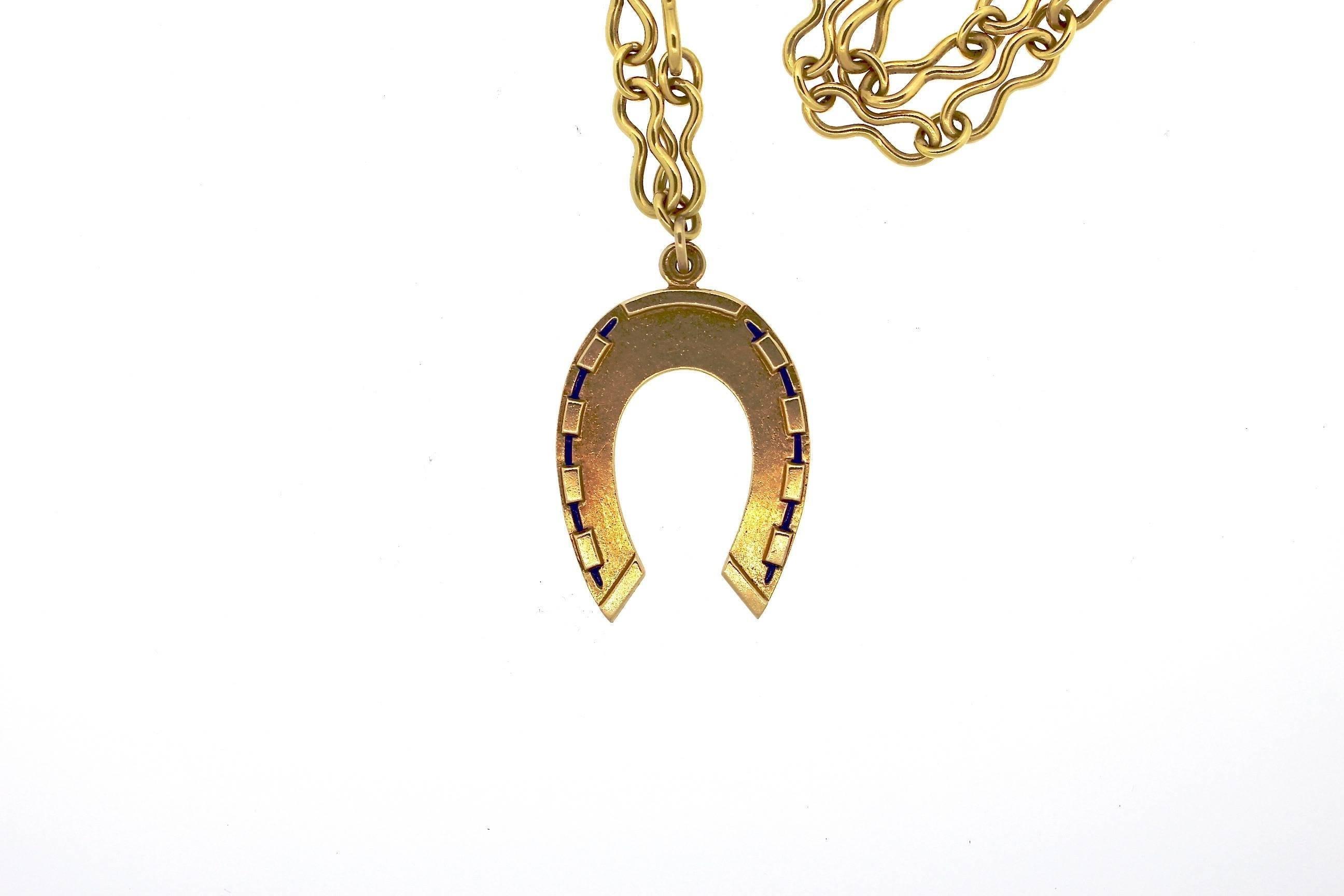 Simple, and easy to wear.  This 14k gold vintage horseshoe pendant is suspended from an 18k gold 26 inch long 18k gold chain.  The chain has an interesting pinched oval link.  The horseshoe is accented by blue enamel around the perimeter of the