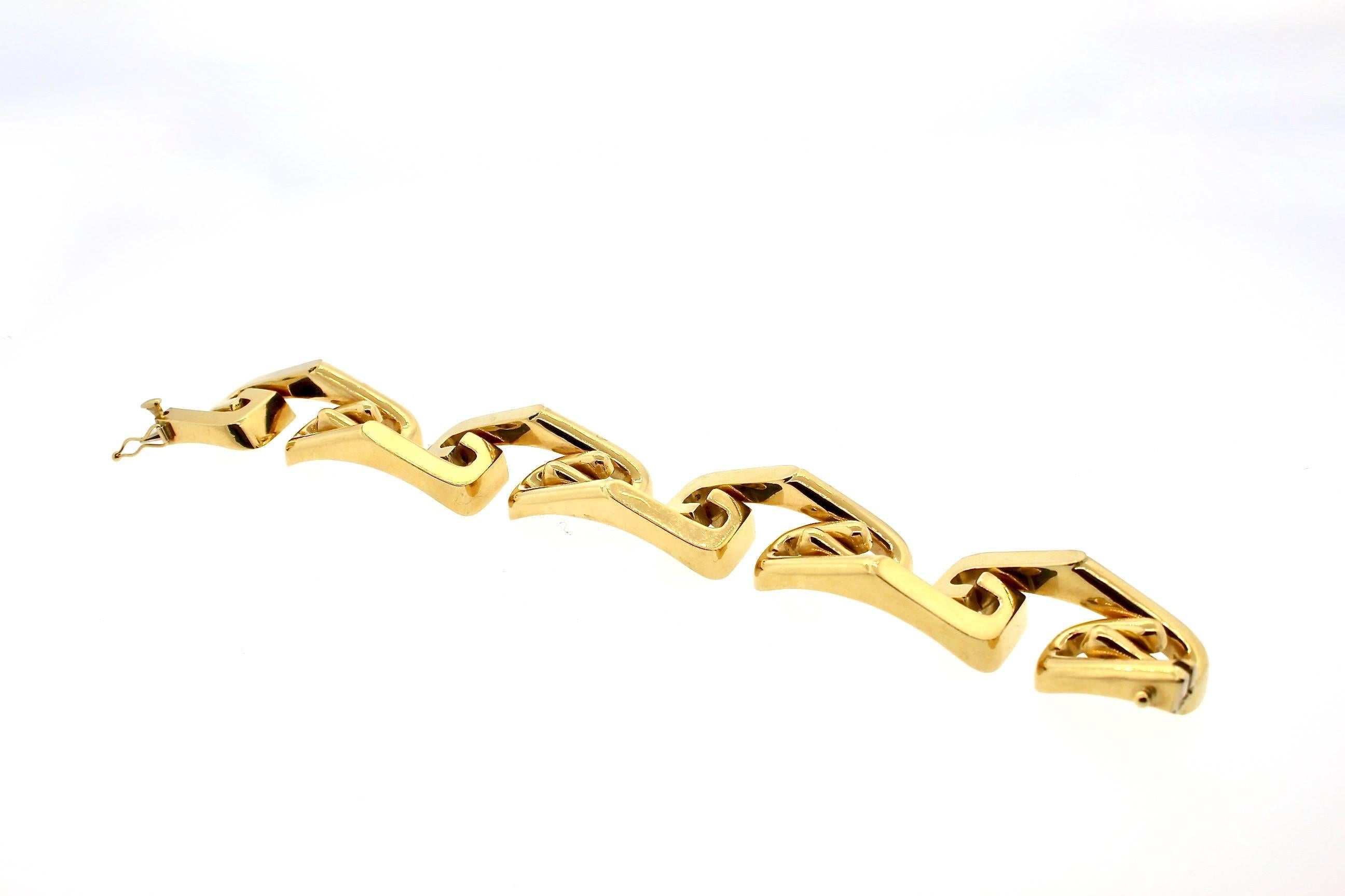 A cool example of a hollow gold 14k bracelet circa 1970.  This wide bracelet is about 3/4 inch wide, and creates a modern dimensional S curve link around the wrist.  It is a nice weight, with a tongue clasp and a safety.  It is curved to fit around