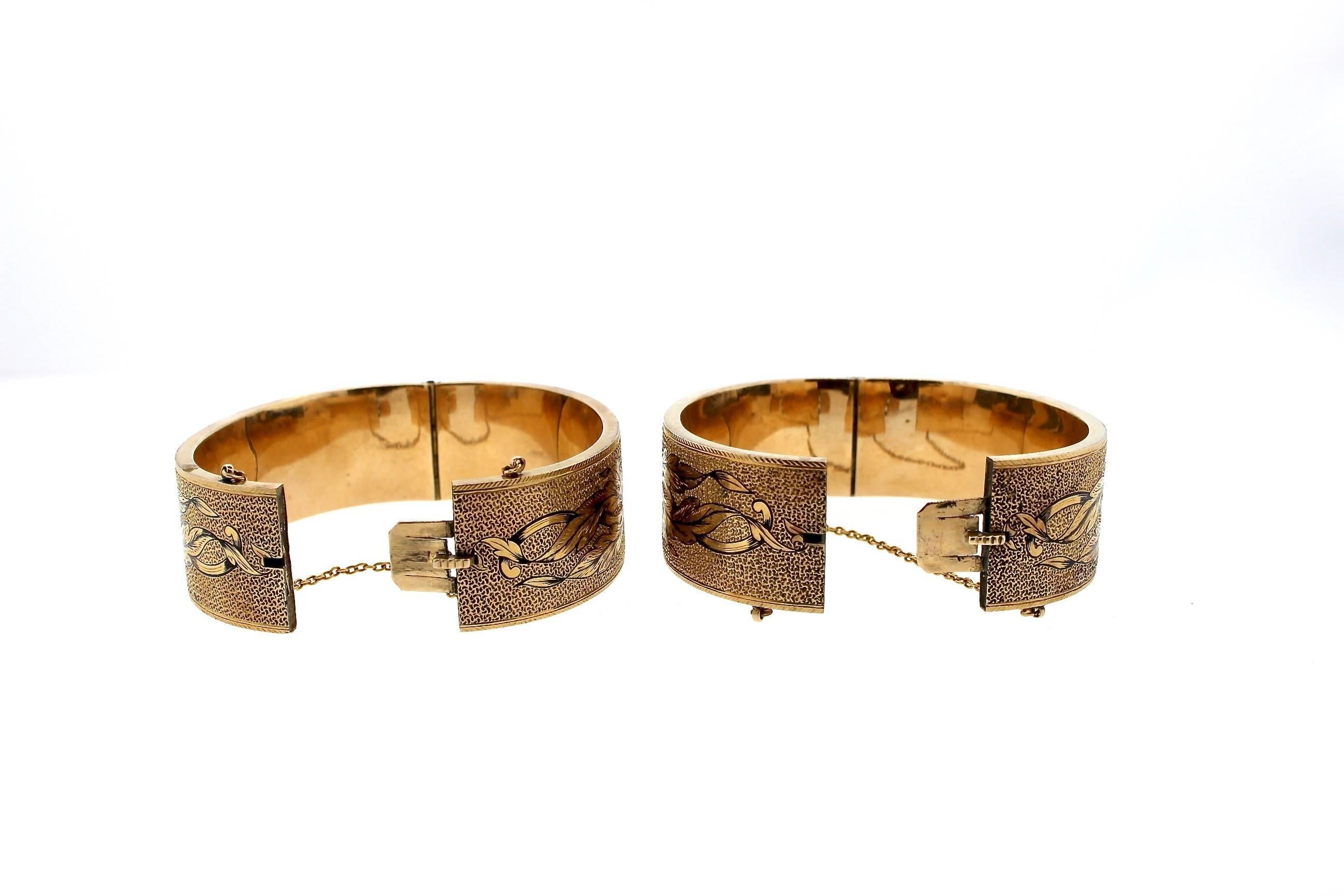 This exquisite pair of Victorian tracery enamel cuff bracelets feature beautiful large pansies on both sides of the cut with leaf scroll work surrounding. The hollow form 14k gold cuff bracelets dates to about 1880. The imagery is the same on both