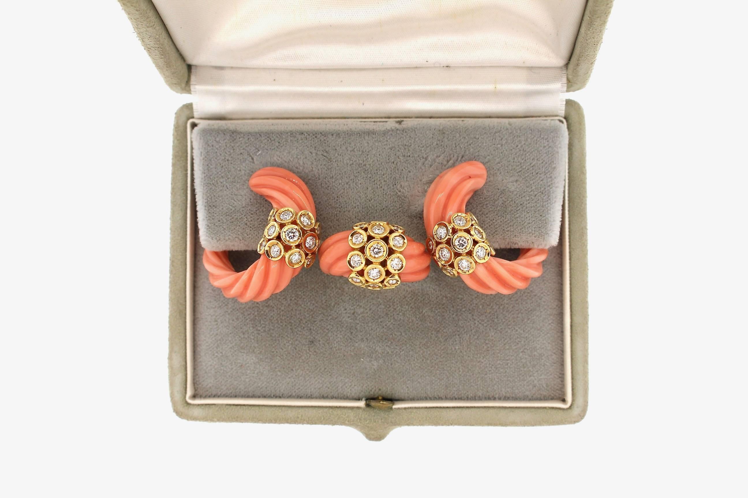 A mid-century modern fluted coral and diamond earring and ring set by Van Cleef & Arpels.  The earrings are modified hanging hoop earrings that fit front to back on the ear.  The ring is of the same fluted coral design.  The set is made in 18k