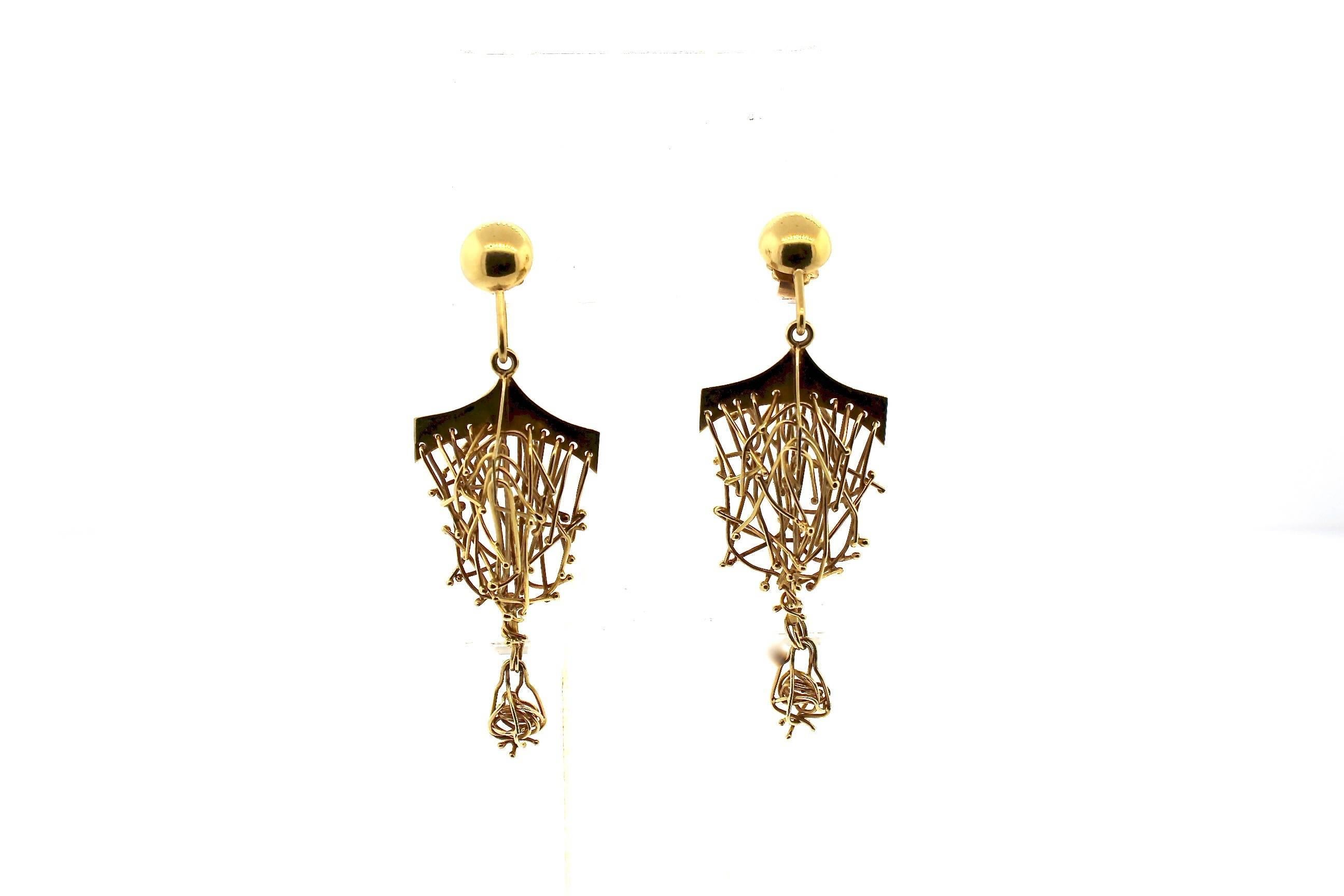 A wild pair of Brutalist style 18k gold earring.  The earring is made of gold wires suspended from a gold top like a chandelier.  It is a fun an interesting pair of earrings.  It measure 2.75 inches long and almost 1 inch wide.  it was made around