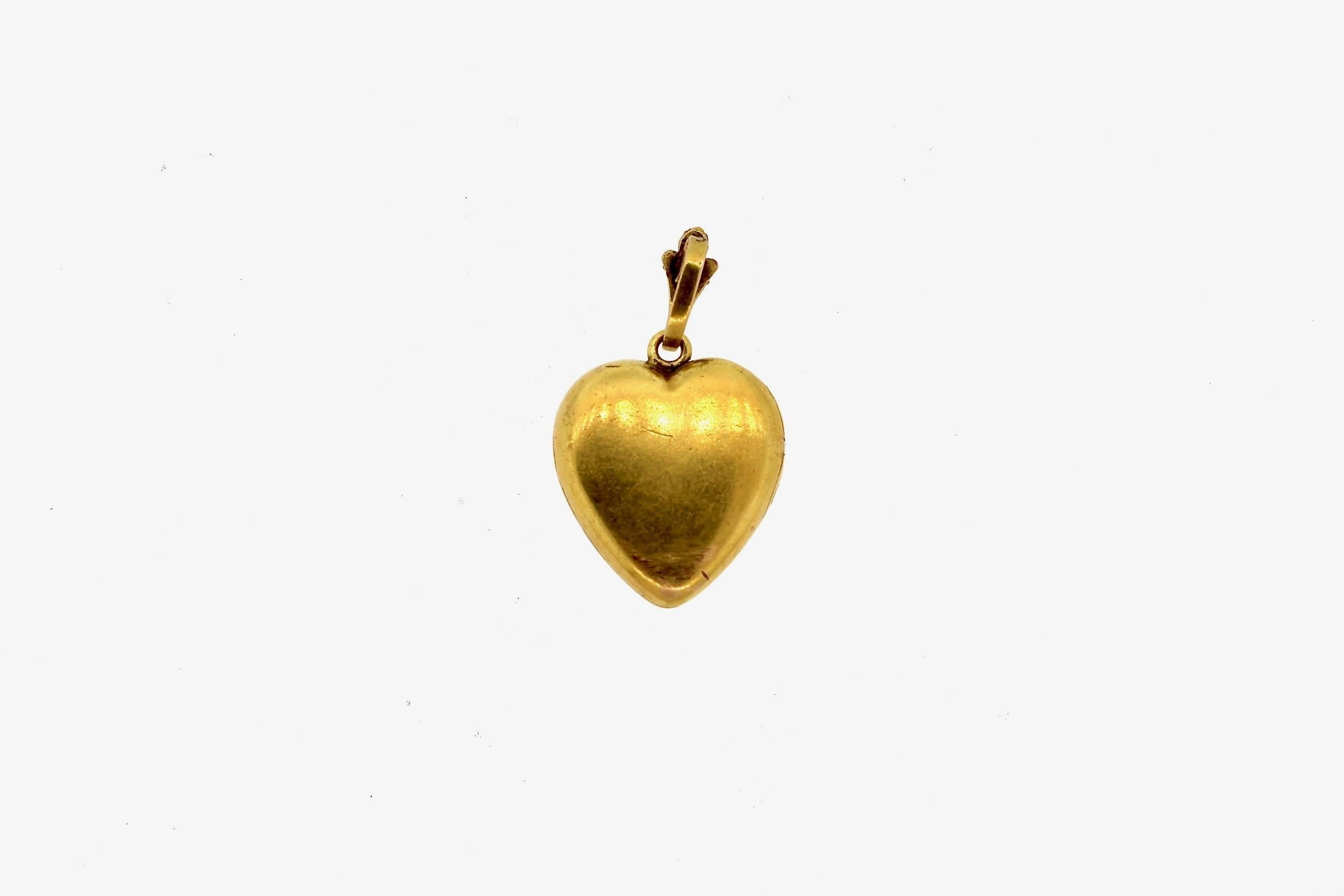 A beautifully engraved gold diamond heart locket with an equally detailed bail.  It's ready to hang from your favorite chain.  The engraving is leaves and flowers, typical of the Art Nouveau period where organic things and nature were incorporated