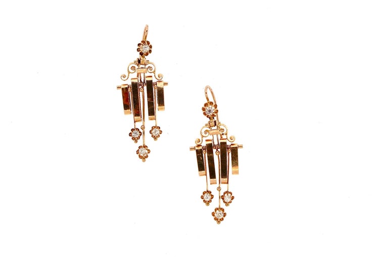 An earring with movement and fringe is fashionable and fun.  These earrings pass the swinging test, as each component swings forward and back freely.  A small diamond on a wire suspends a scroll that has a bar where gold oval hoops and diamond darts