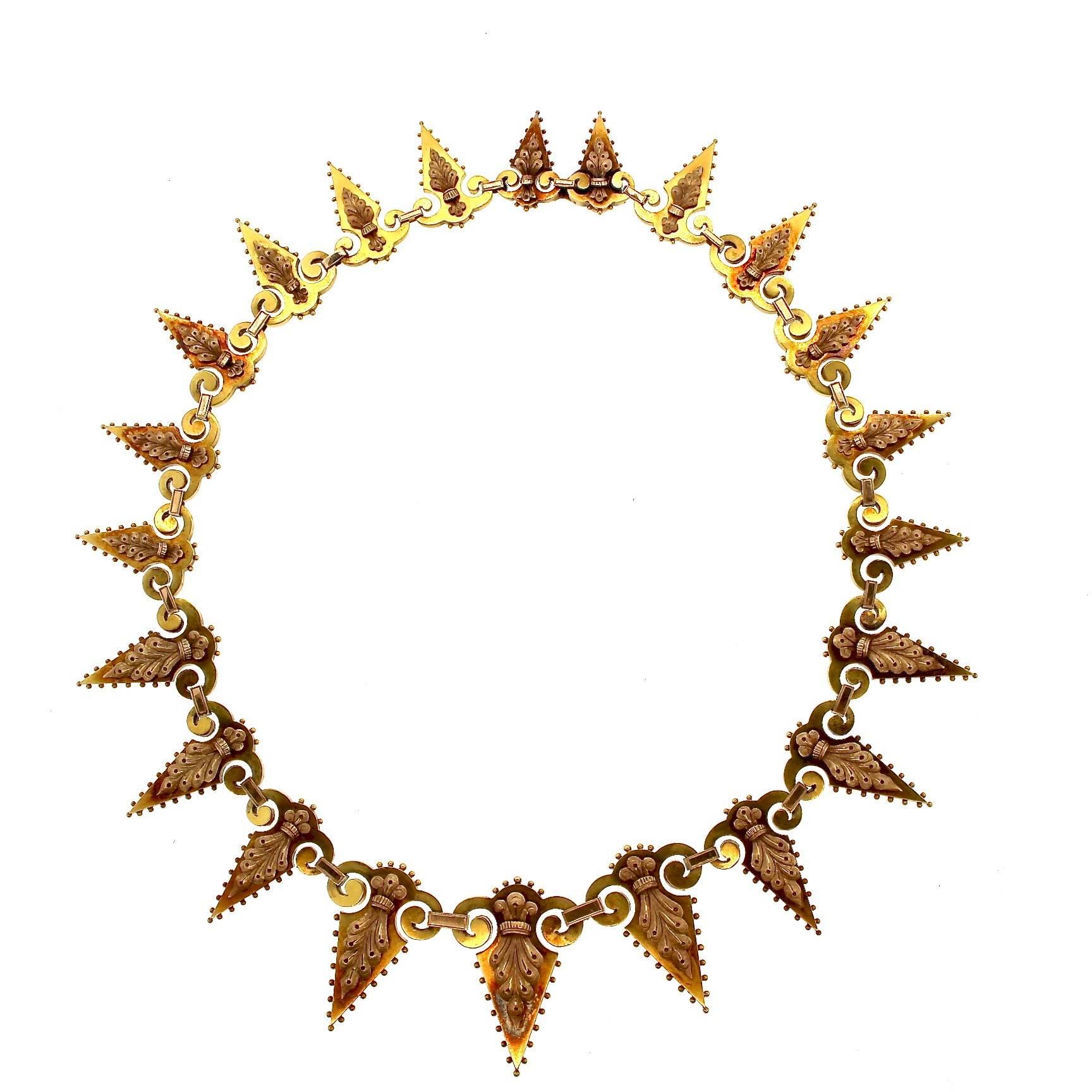 A beautifully crafted antique Victorian two color gold dart fringe necklace.  Each piece is designed as a triangular urn hooked together with each other.  Each dart pice has rose toned leaf scroll pieces on them and large granulation around the