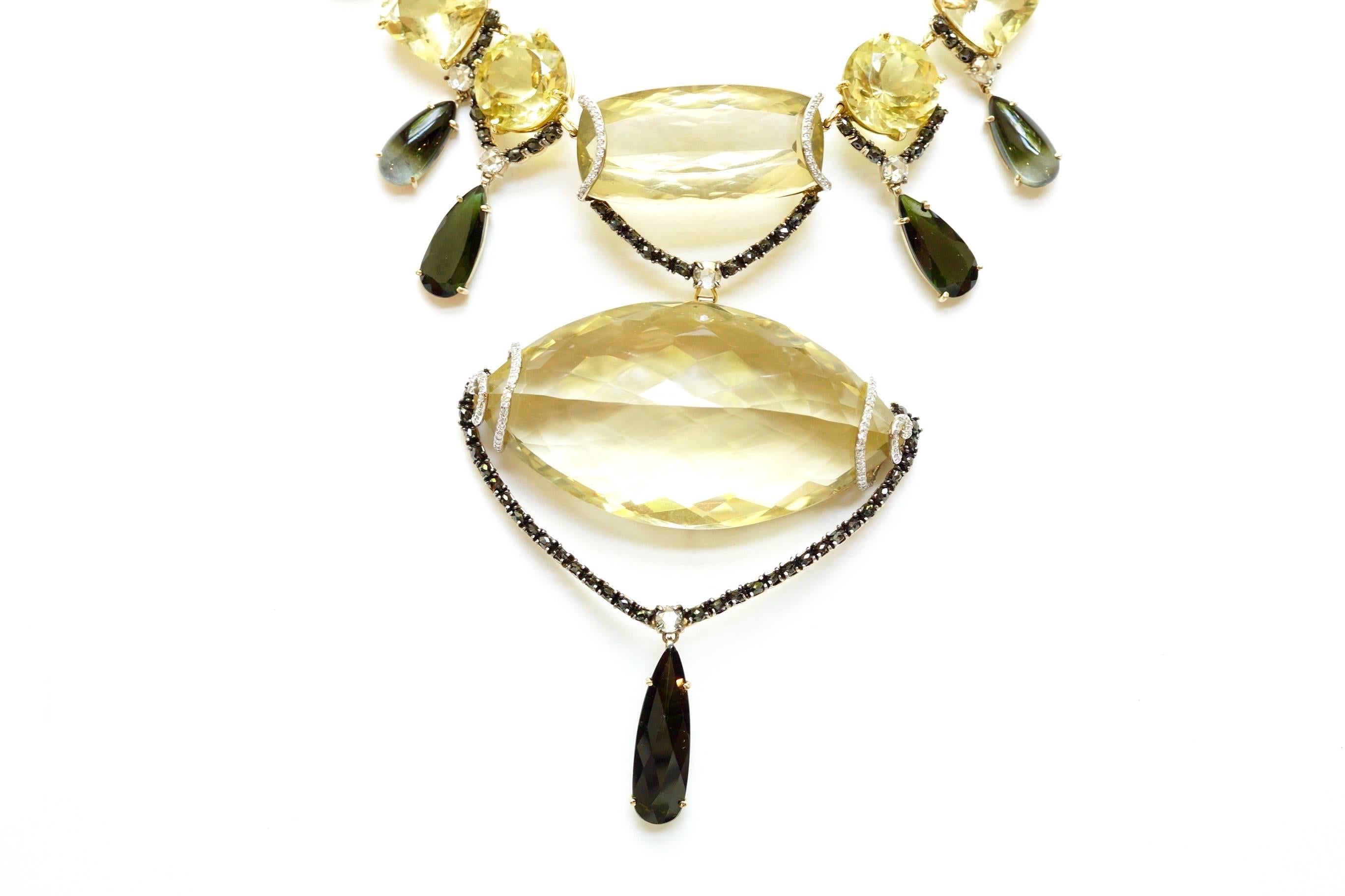 Melanie Necklace
An eighteen-karat yellow gold seventeen-inch necklace depicting many cuts and shapes of the gemstone lemon quartz.
Beginning from the center is an elongated cushion-shaped lemon quartz, draped with a black diamond-encrusted swag. 