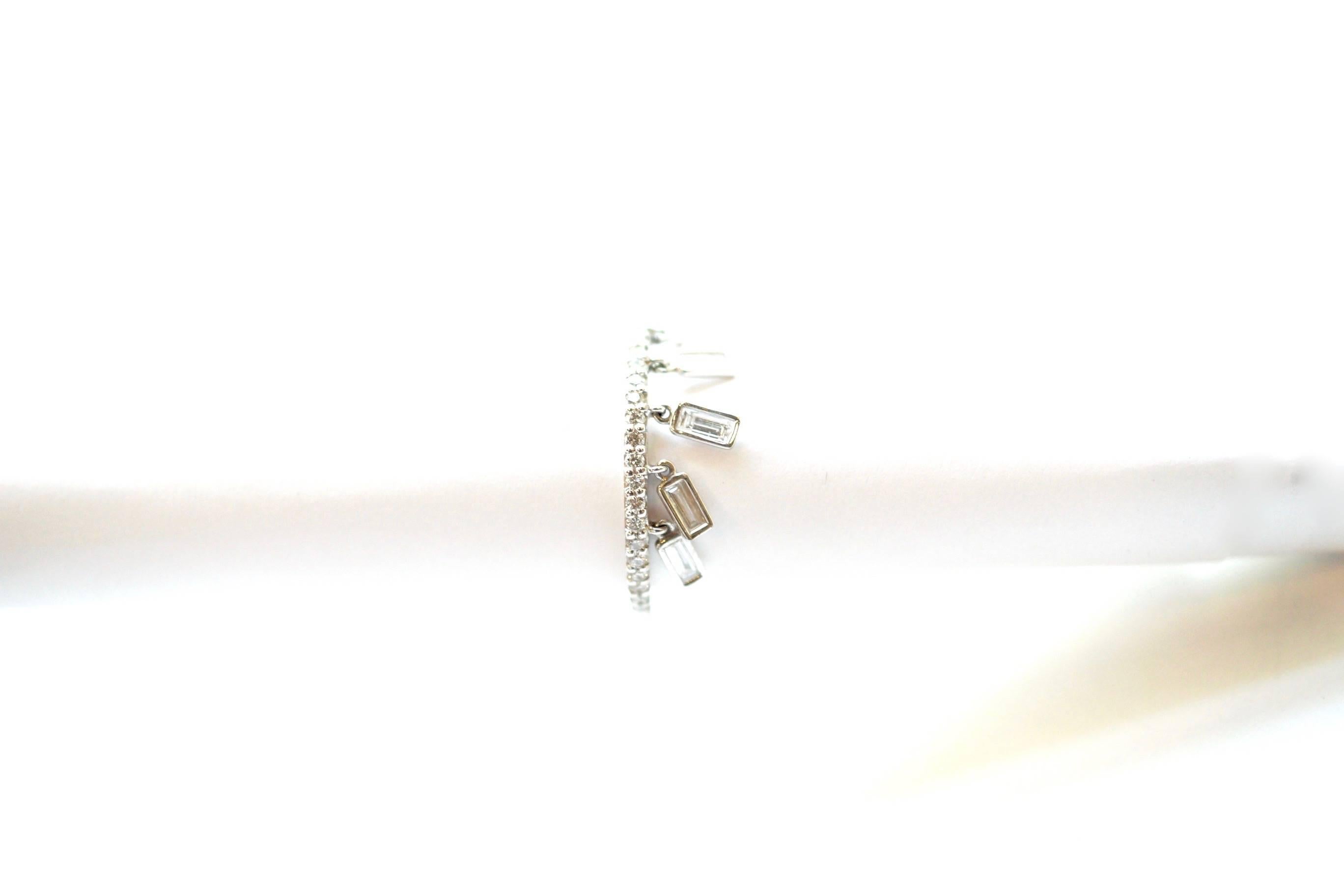 Shimmee® Ring
A platinum ring set ¾ of the way with white diamonds.  Suspended unpredictably off one side of the ring are five flexible white diamond baguettes.  This modest movement adds discreet glitter to the diamonds.  
Size 6 - adjustable upon
