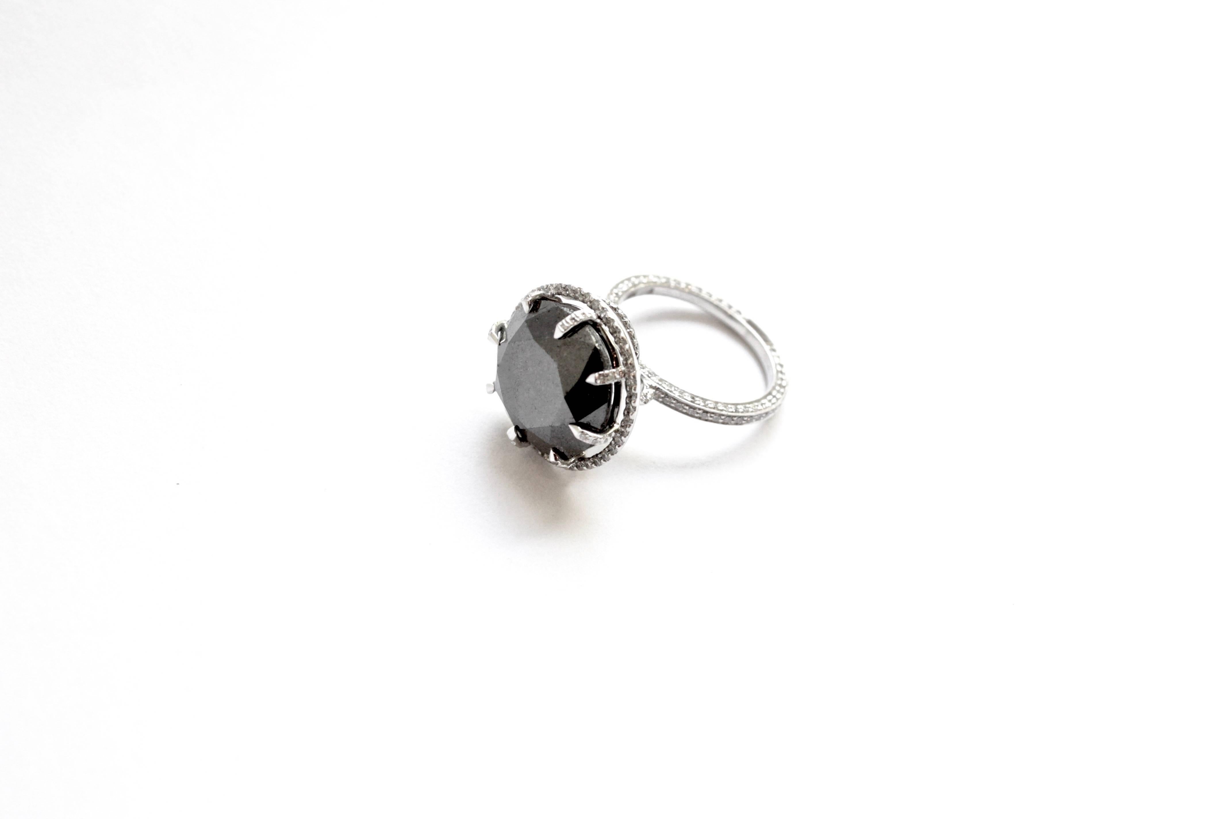Moosh Ring
A platinum ring showcasing a 14.60 carat natural round black diamond, completely set in white diamonds.  The center stone is encircled in diamonds, which then trail and twist along the side to meet the three-sided white diamond encrusted