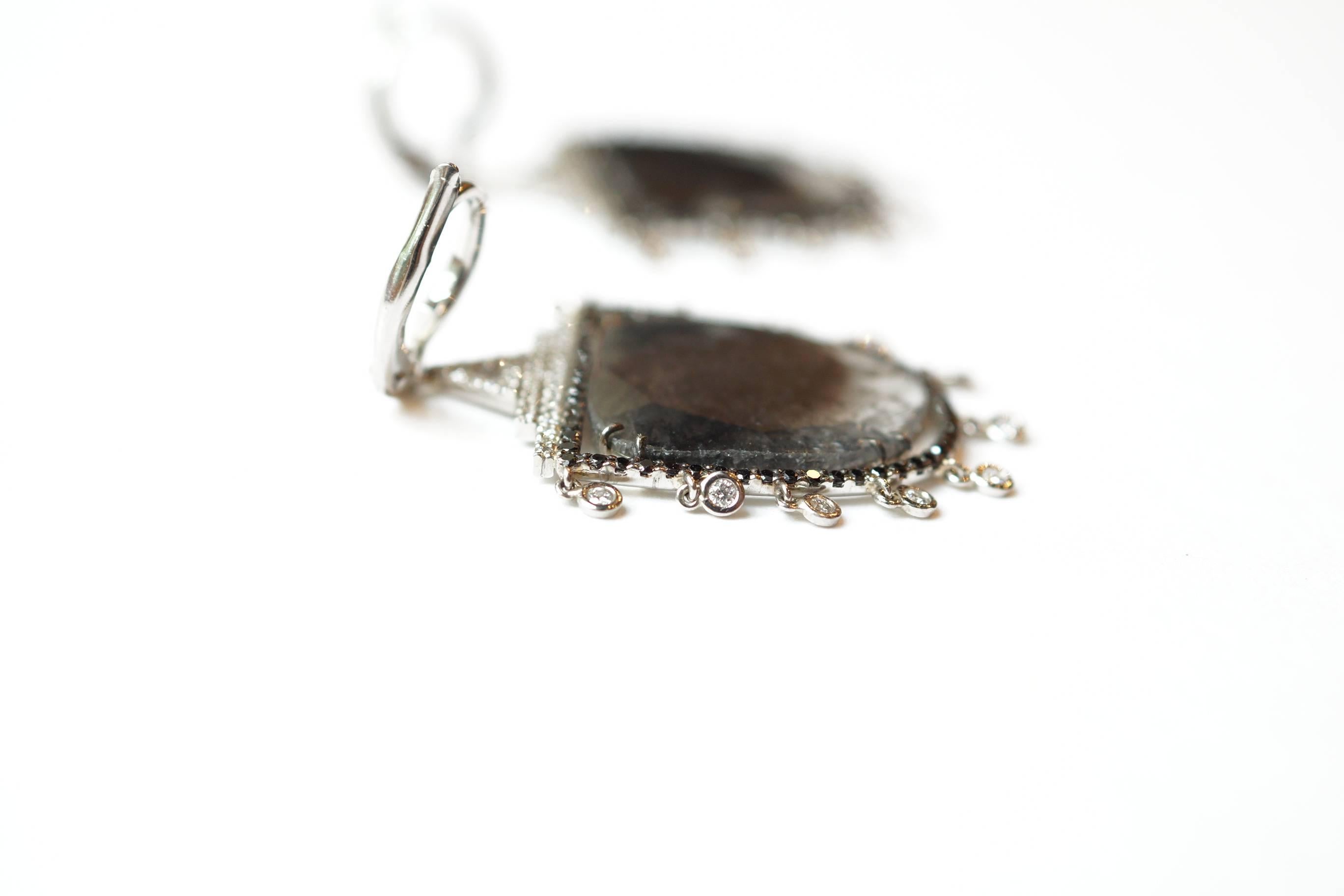 Danni Eardrops
A large pair of platinum eardrops, composed of a pair of large natural dark grey diamonds, which have been encased in black diamonds.  These eardrops are suspended from a white diamond-encrusted earwire, followed by three rows of