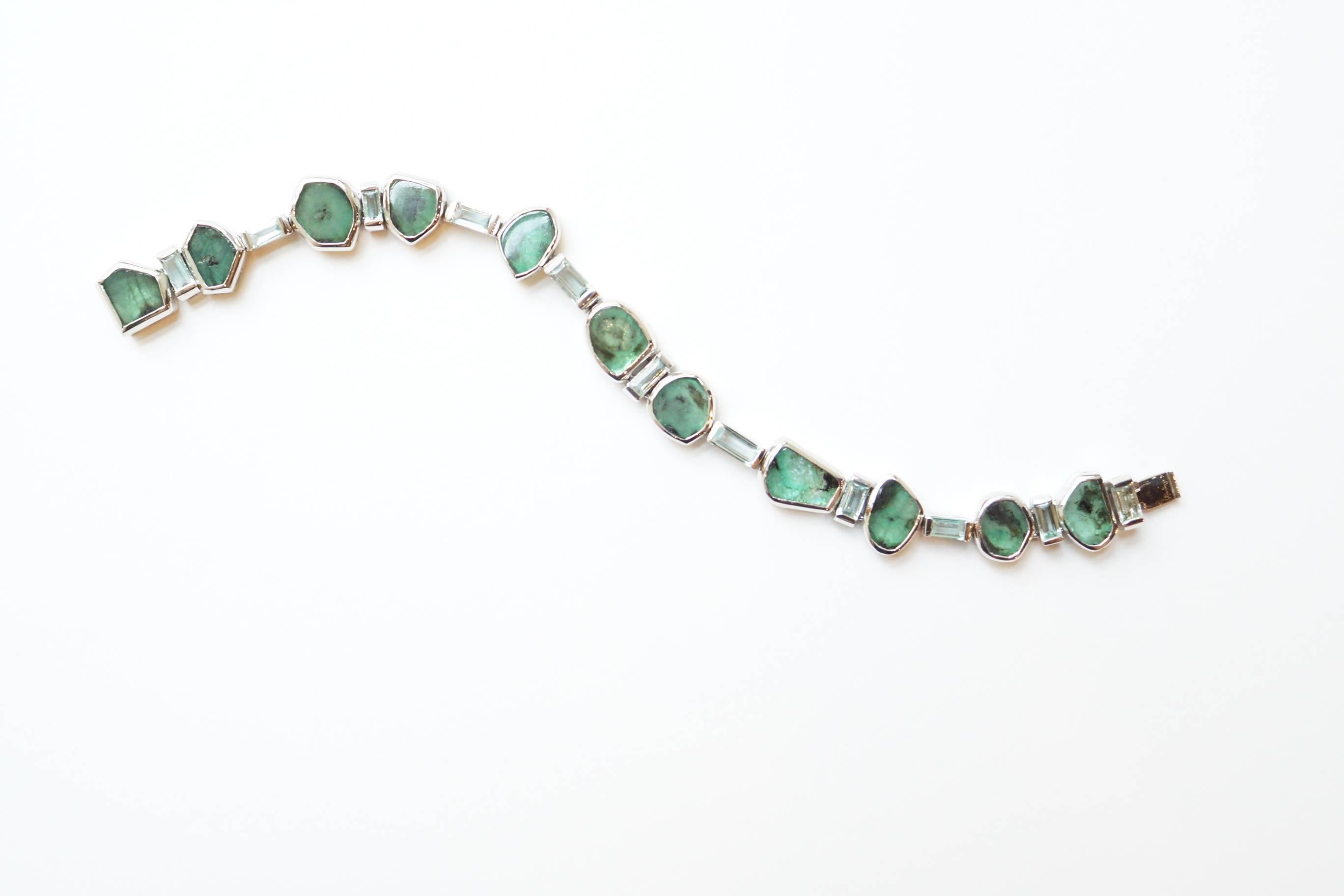 Manza Bracelet
A flexible bracelet featuring two different types of emeralds, set entirely in blackened platinum.  The gems have been placed in alternating order of emerald slices and Zambian emerald baguettes of a very unusual mint colour.