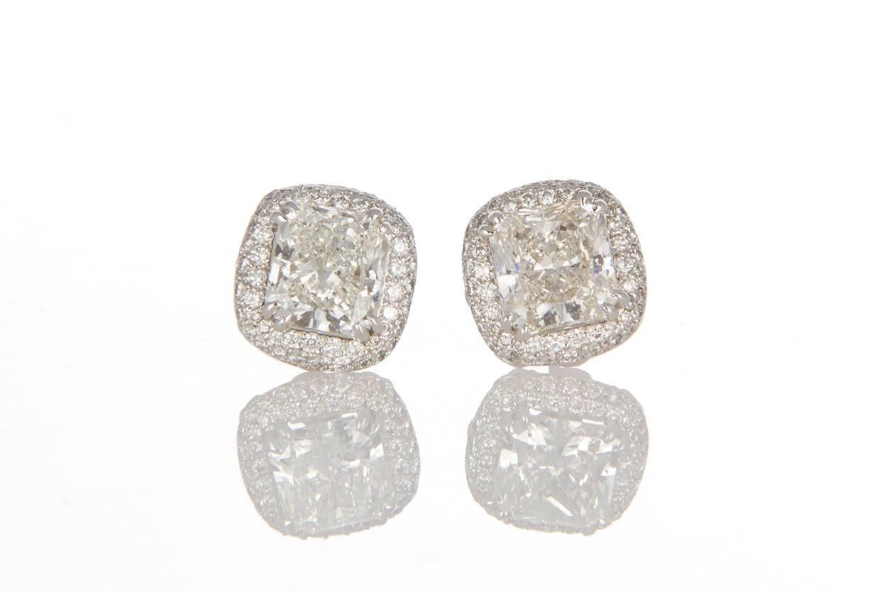 Ladies Michael Beaudry Platinum & Diamond Halo Stud Earrings. These beautiful earrings feature 5.20ctw Radiant & Round Brilliant Cut Diamonds set in .950 Platinum Halo Setting. The center stones are both 2.04ct I/VVS Radiant cut Diamonds set