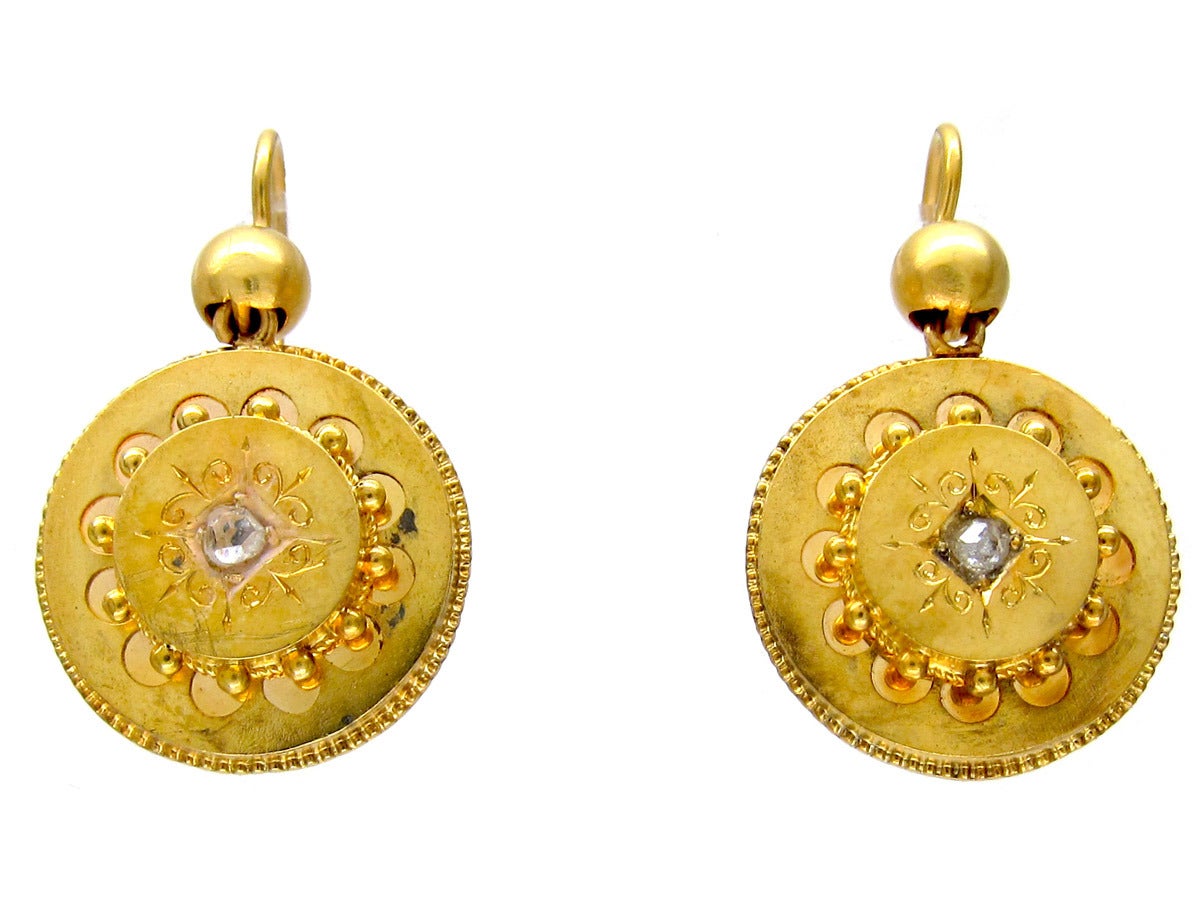 A smart pair of 15ct gold earrings in good condition, each containing a central rose diamond. They were made circa 1870.