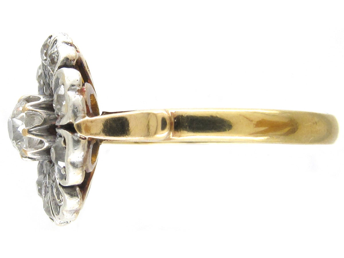 A natural looking flowerhead ring set with old mine cut diamonds in a white gold setting on an 18ct gold shank. It is unusual and pretty and would either be a lovely engagement ring or a dress ring.