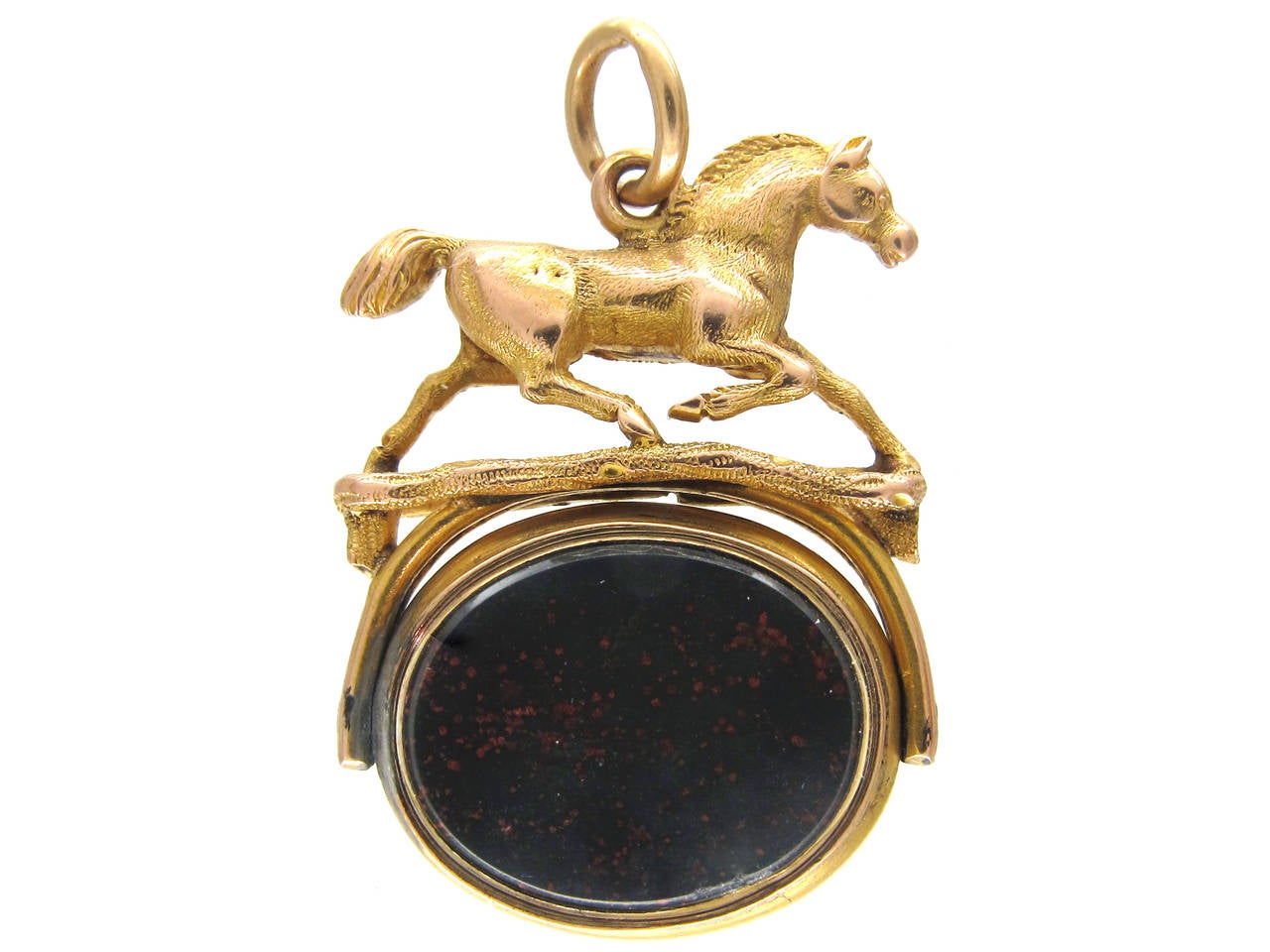A rare 15ct gold revolving seal set with a banded carnelian and a bloodstone. There is  a model of a trotting horse above.
