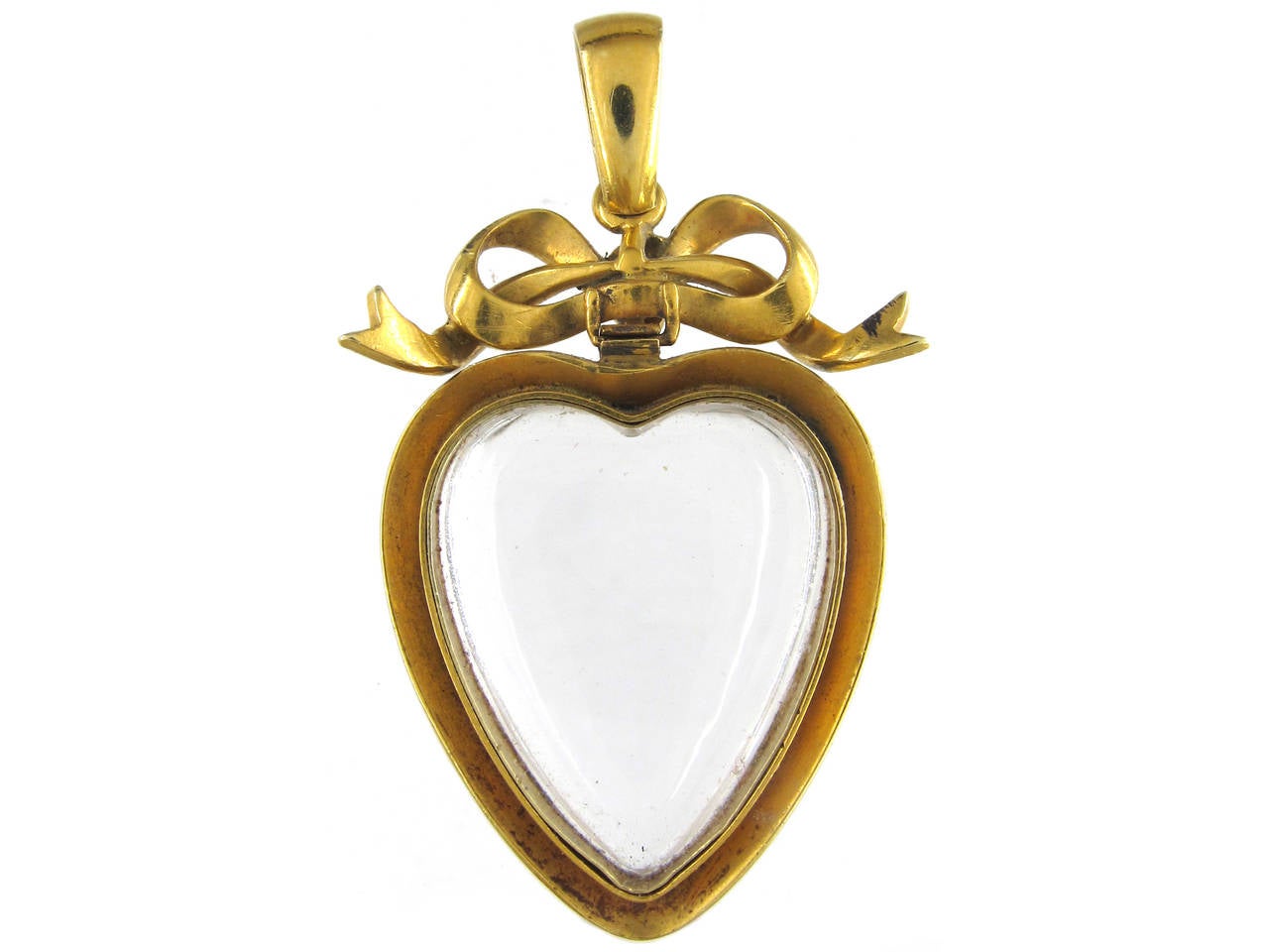 A rare 18ct gold heart shaped pendant set with a rock crystal inner heart and natural split pearls. It has a pretty bow top set with split pearls and a loop similarly set with pearls. It was made circa 1890.