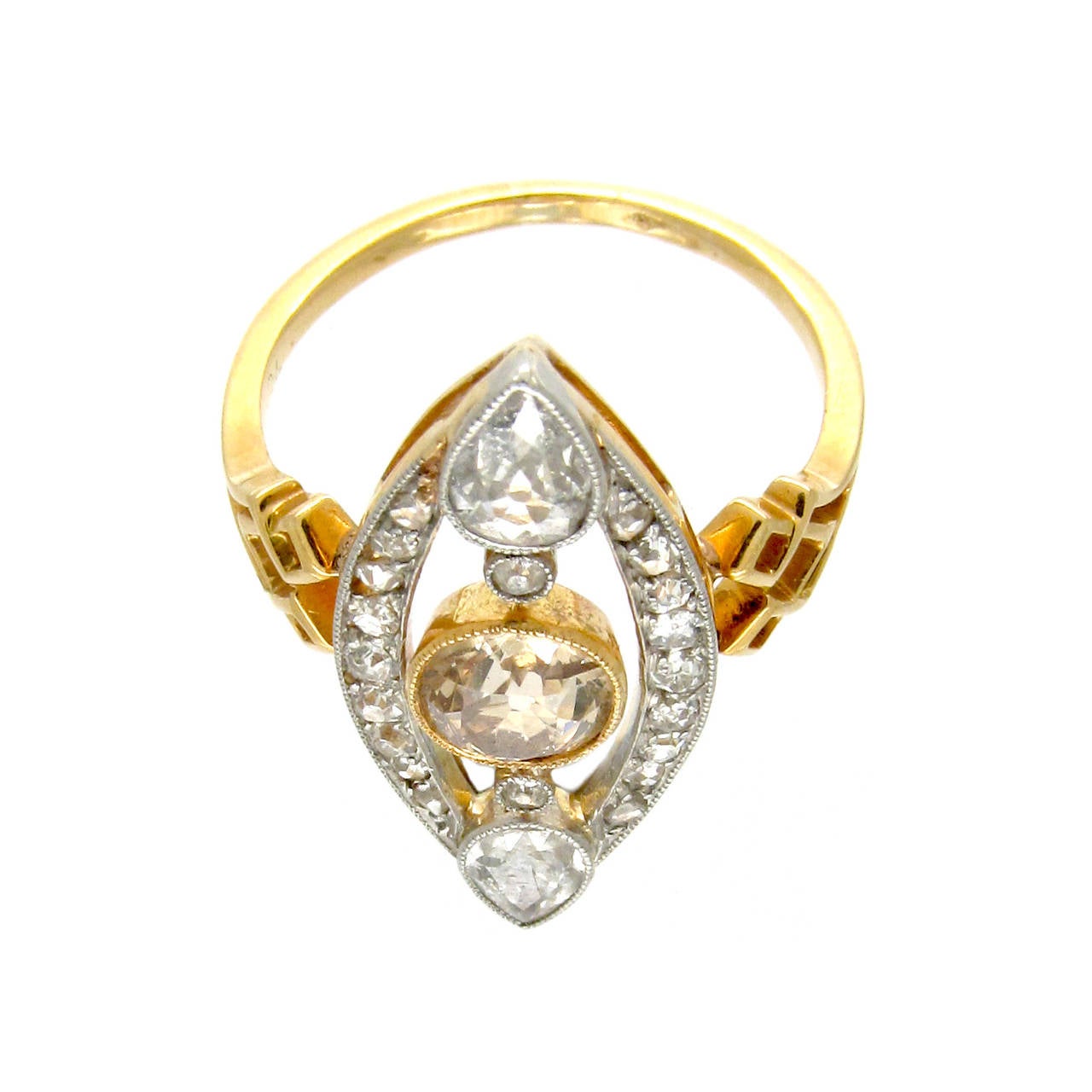 A gold and diamond ring set to the centre with a cinnamon diamond and a pear shaped diamond to each tip of the central diamond motif. The sides of the diamond are set with smaller diamonds. The diamond design is repeated in the gold shank.